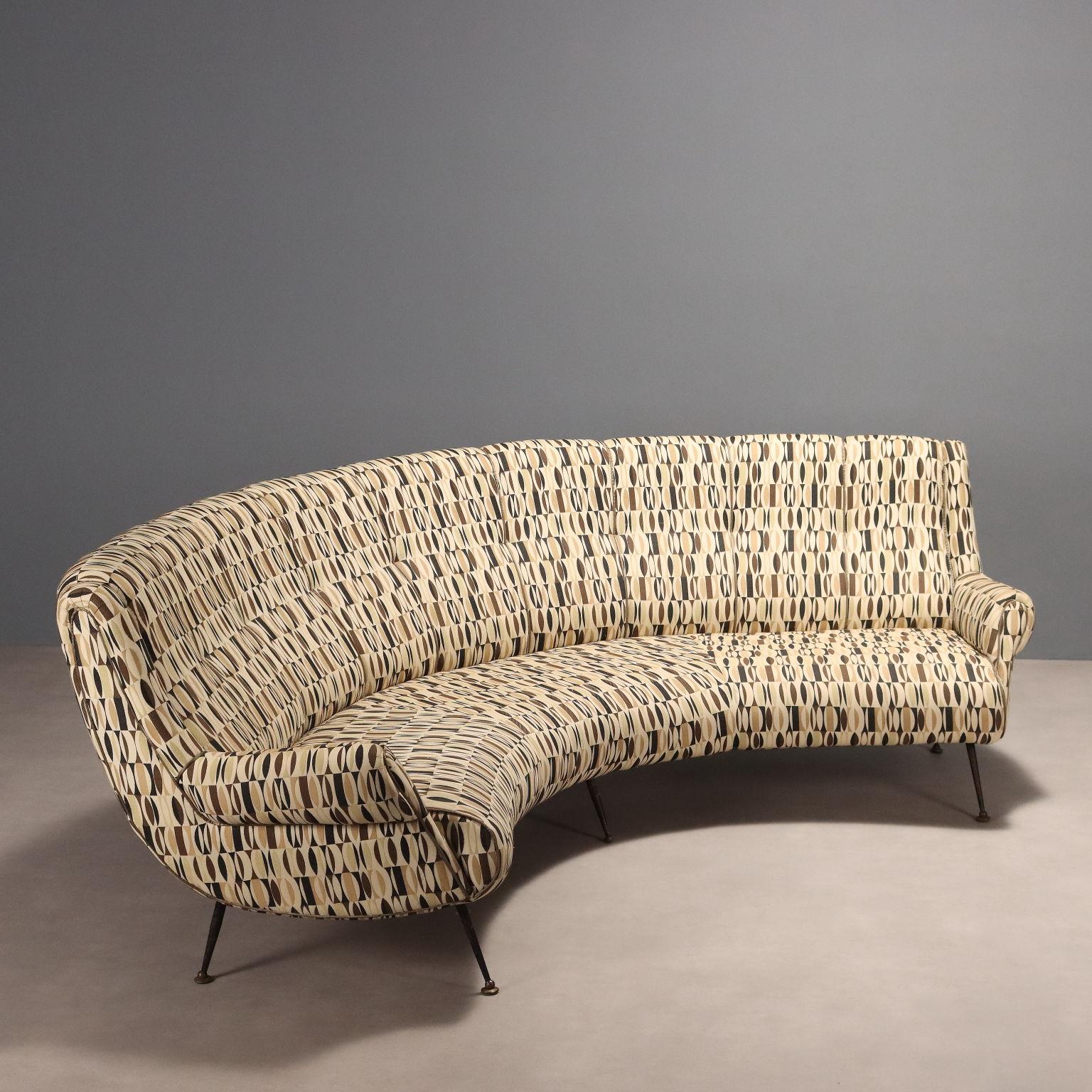 Divano vintage tre-quattro posti dalla linea curva con gambe in metallo smaltato, piedini in ottone, imbottitura in espanso e rivestimento in tessuto optical nei toni del beige, marrone e nero. Seduta in buone condizioni generali con rivestimento