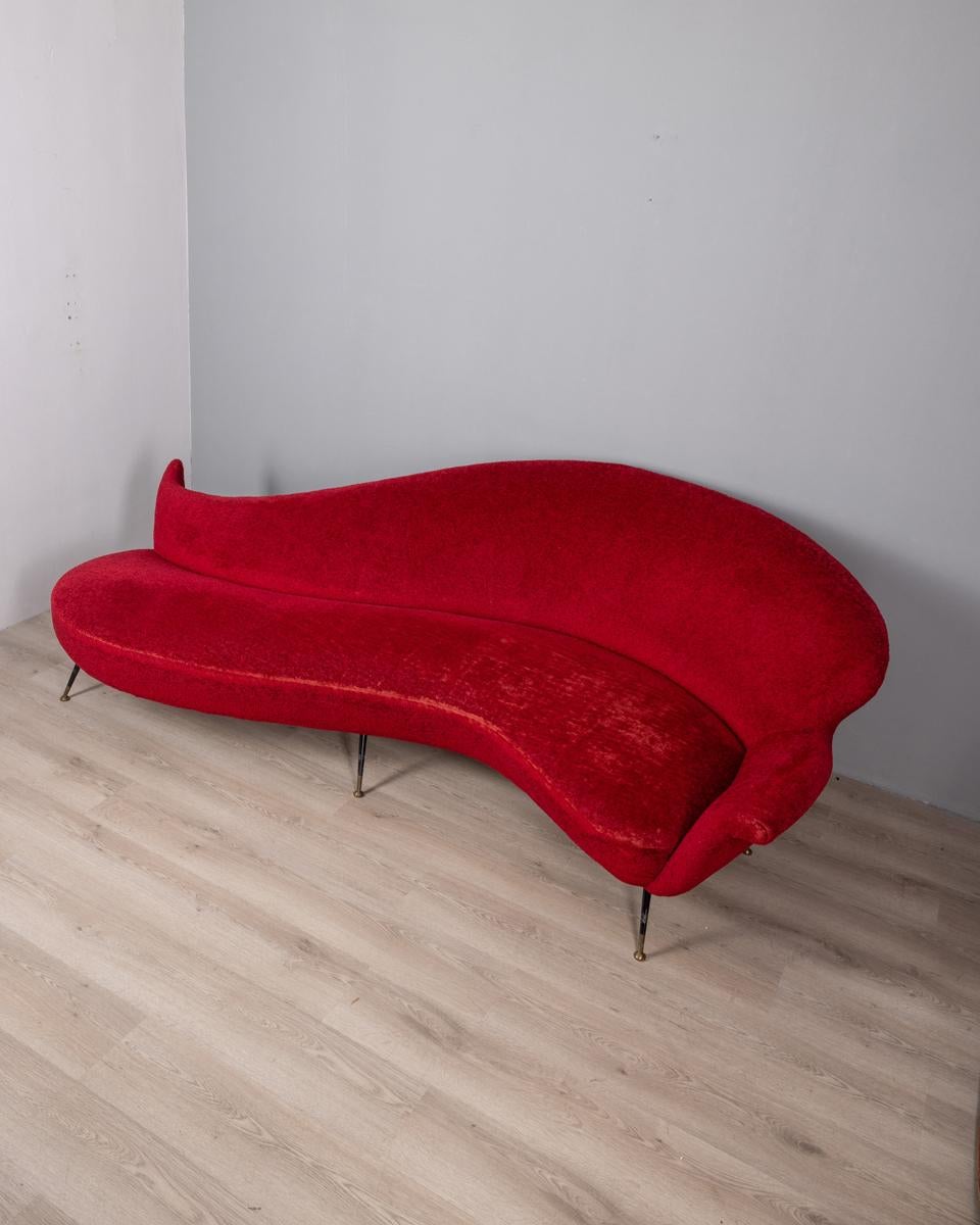 Large curved sofa with red velvet upholstery, black metal legs with gilt brass finials, Italian design, 1950s.
