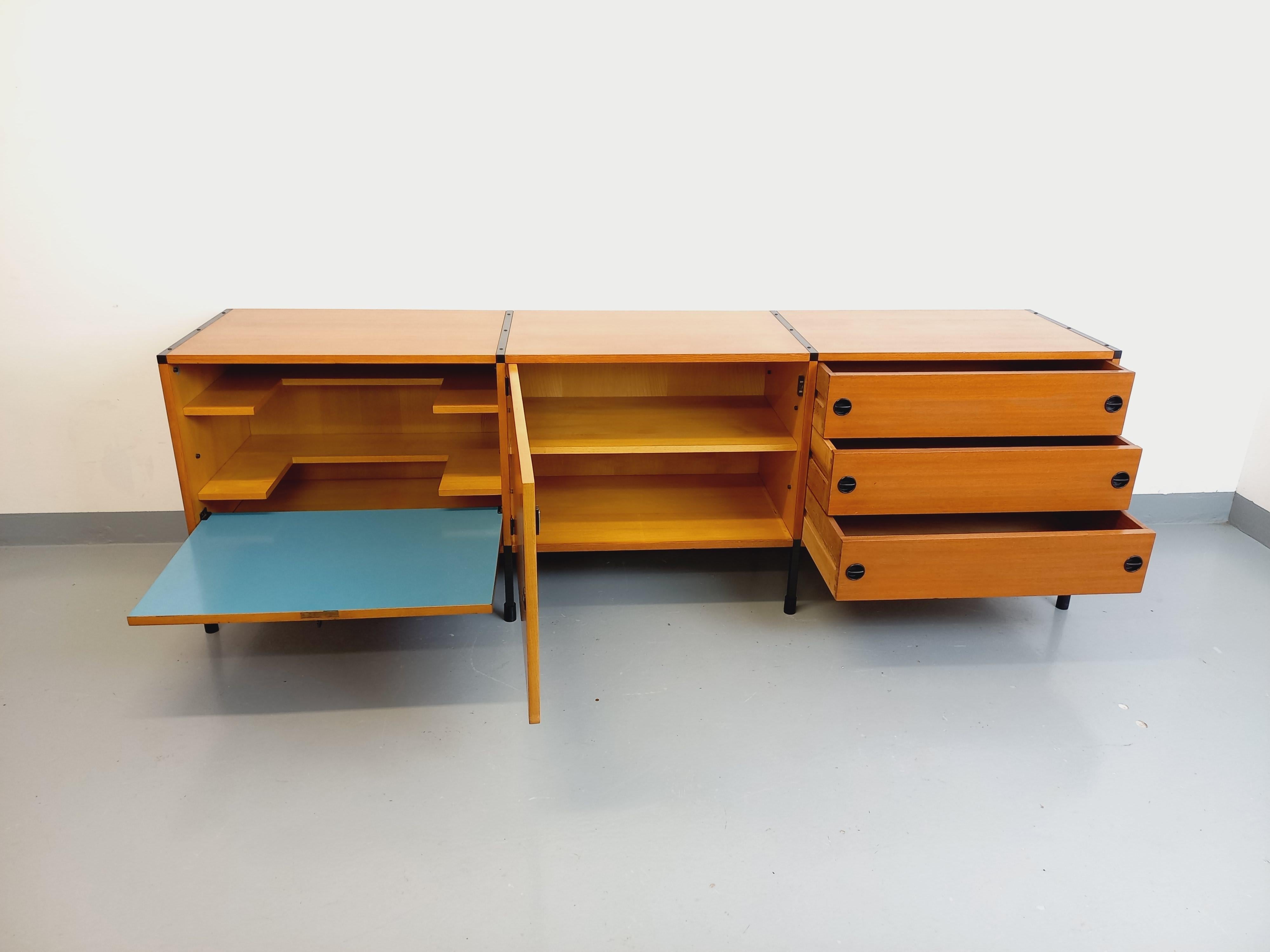 Grande enfilade basse vintage ARP Minvielle des années 60 attribuée à Pierre Guariche, Michel Mortier et Joseph-André Motte, de style moderniste, en bois de frêne, pieds en métal noir, 1 porte avec rangements étagères, 1 porte abattante avec clé et