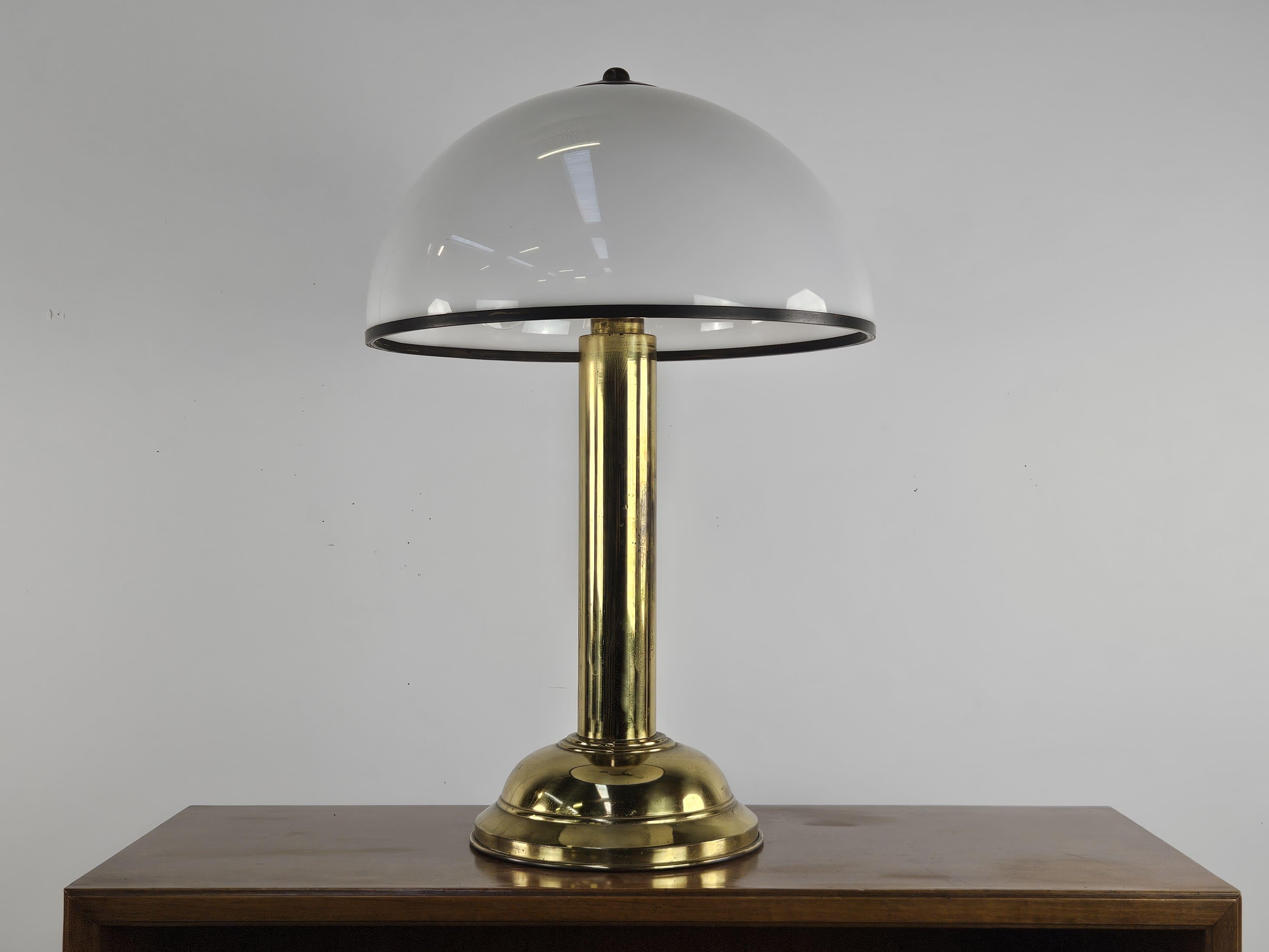 Rare lampe de table en laiton brossé avec un dôme en plexiglas blanc entouré d'une petite bordure en laiton.

Lampe modèle 