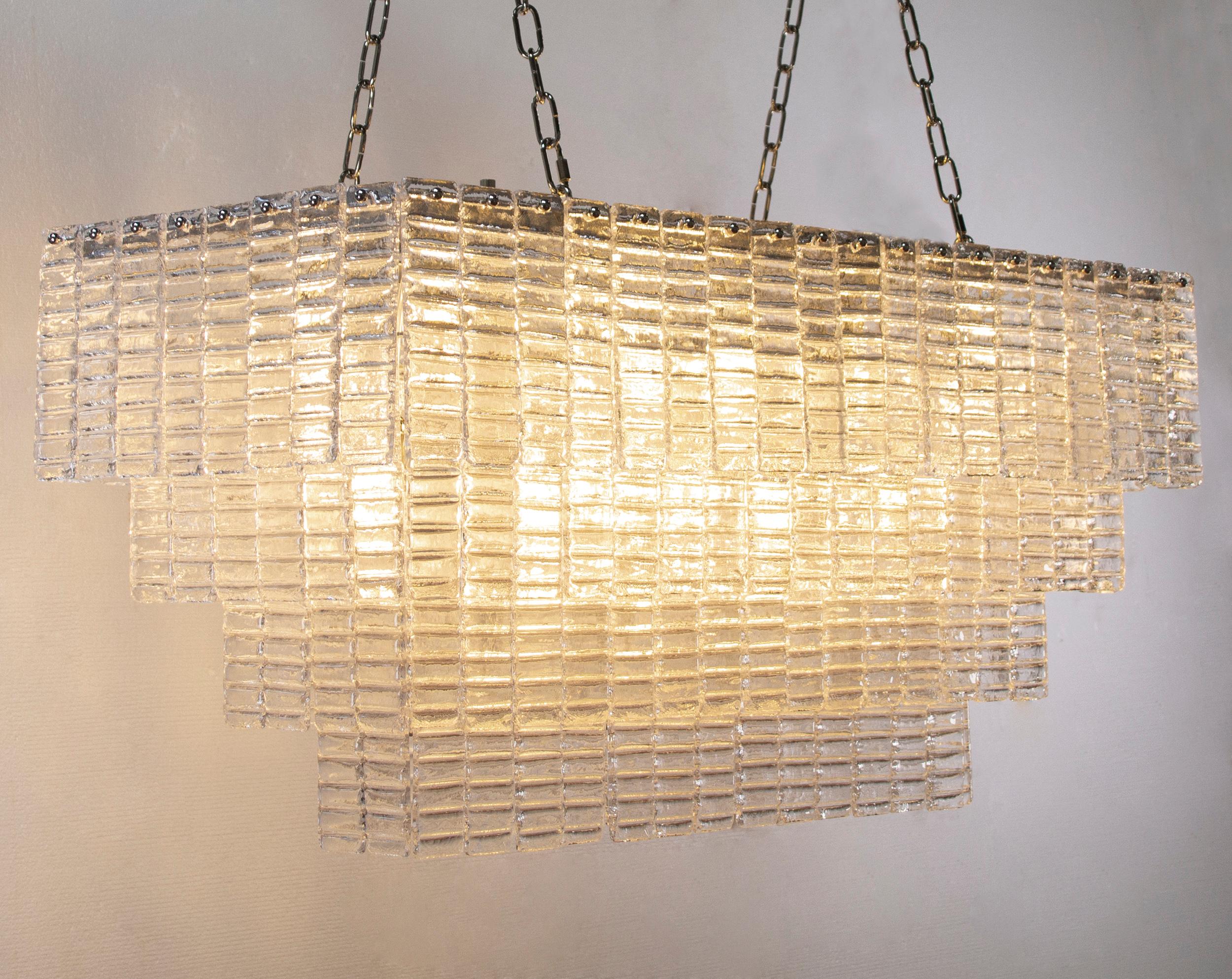 Grande lampadario con listelli vetro di Murano ispirato al mid-century italiano

Direttamente dalla fonte:
Non siamo semplici rivenditori, ma produttori diretti! Situate vicino a Venezia, nel cuore dell'industria vetraria di Murano, queste applique