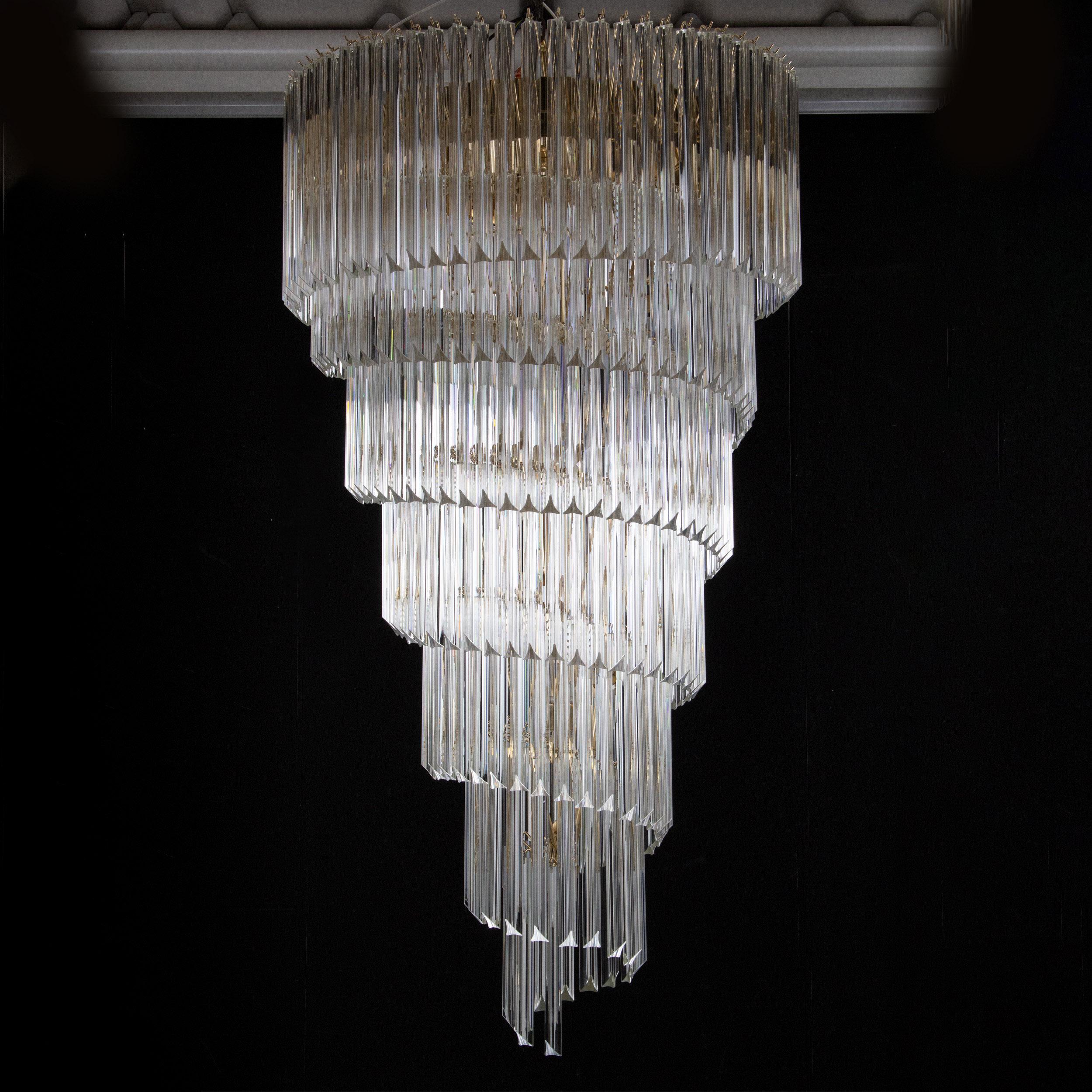 Grande lampadario plafoniera a spirale con triedri in vetro di Murano ispirato al mid-century italiano.

Direttamente dalla fonte:
Non siamo semplici rivenditori, ma produttori diretti! Situati vicino a Venezia, nel cuore dell'industria vetraria di