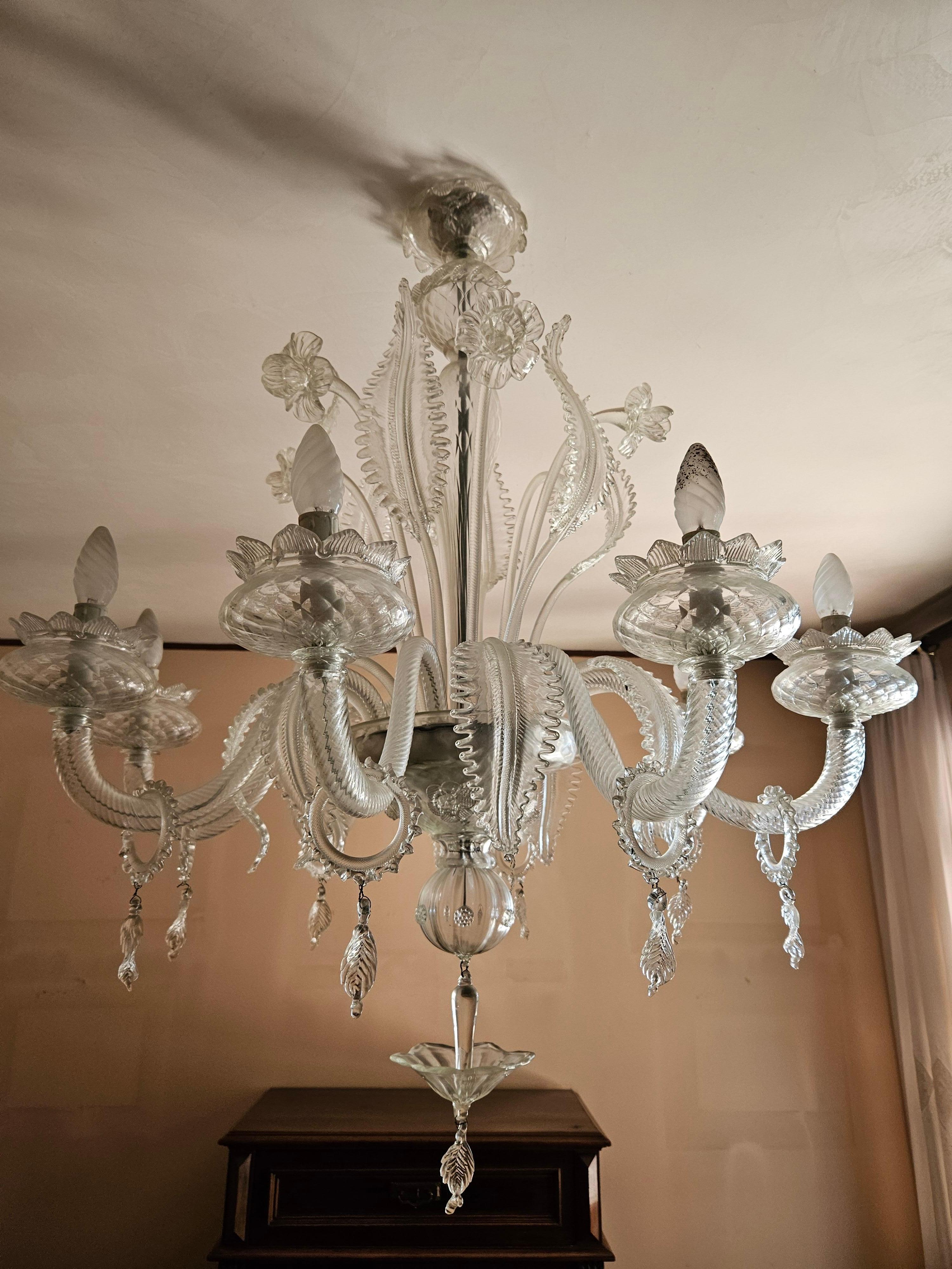 Large and elegant Murano glass chandelier with eight light points and various floral-themed decorations.

Very distinctive, suitable for classy and design environments.

Bulbs not included..

