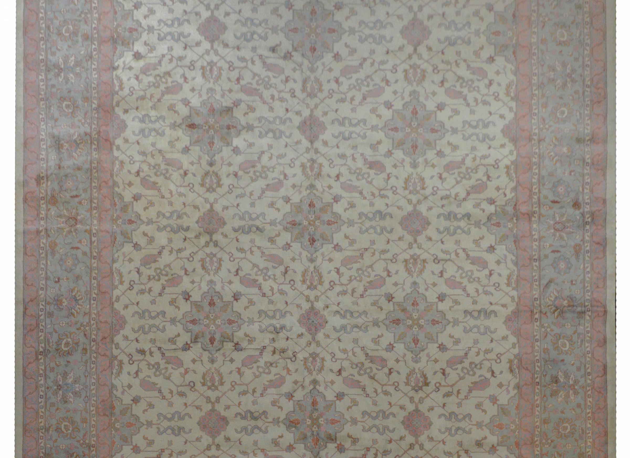 A Grande mid-20th century Indian Mahal rug with a wonderful all-over trellis pattern with large-scale floral medallions and scrolling vines and leaves on a cream colored background. The border is fantastic with a large-scale floral and vine