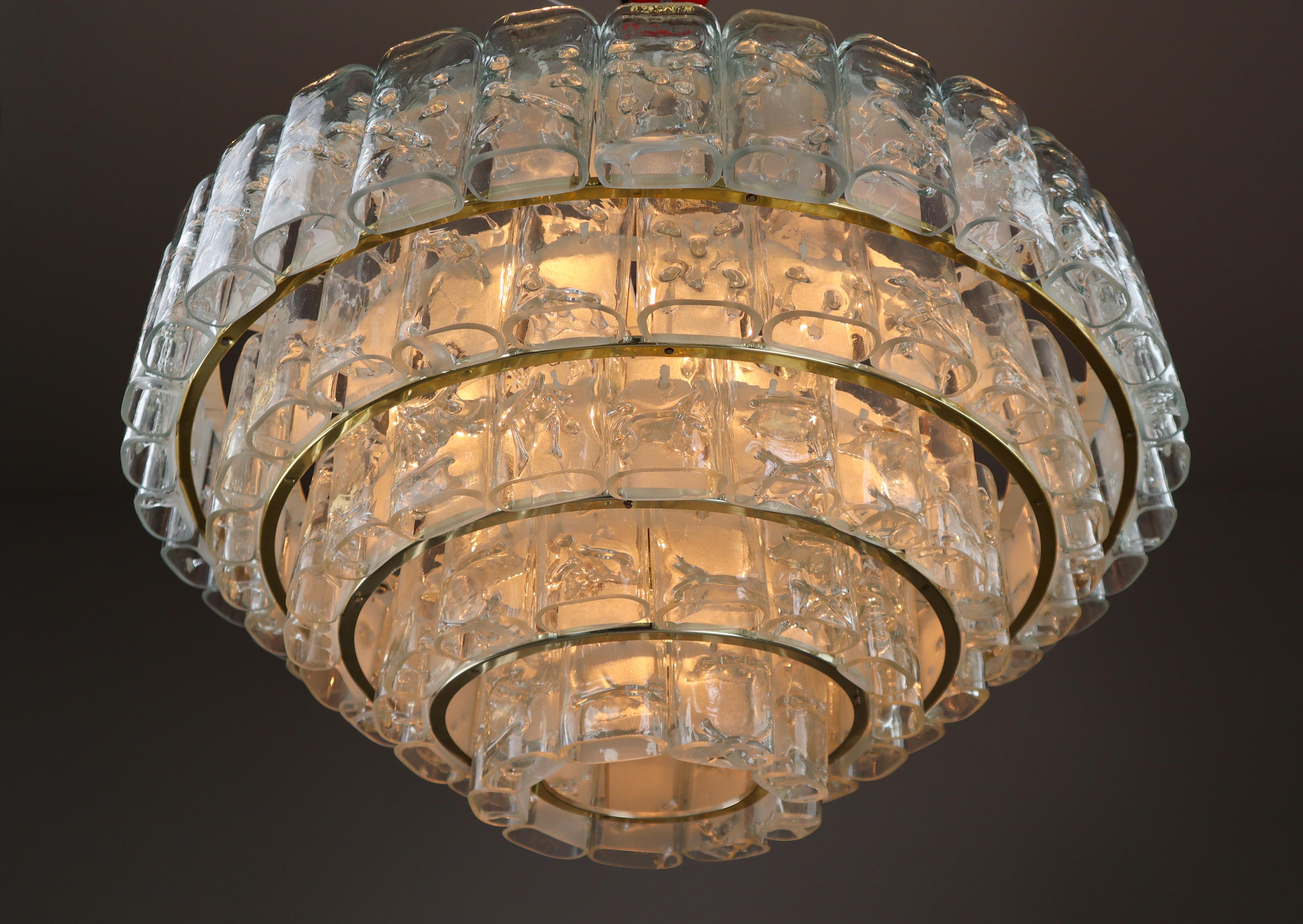 Grande Midcentury-Modern Chandelier by Doria Leuchten, Germany, 1960s.

The fixture consists of layers with several hand-blown textured glass tubes (and five reserves) mounted on a frame arranged in concentric rings. This size high-end Doria flush