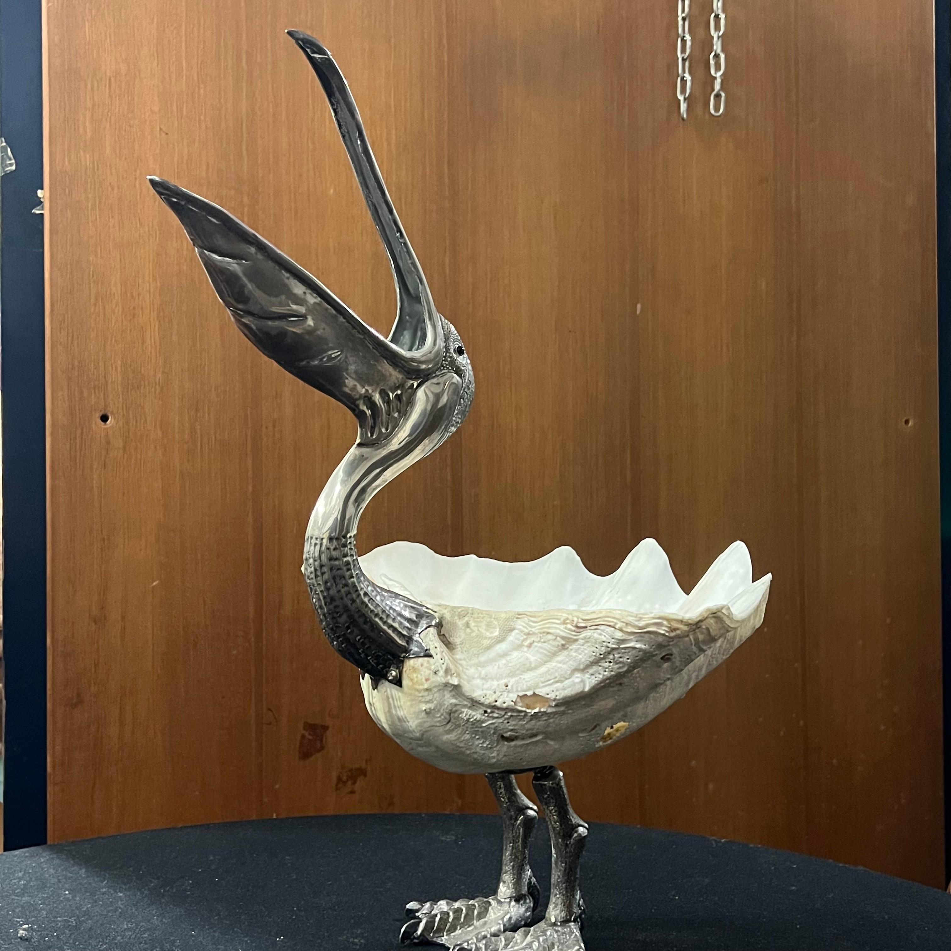 Large sculptural drainer depicting a pelican made with a large central shell and handcrafted and embossed metal elements bathed in silver.
This work, from the 1970s, was created by Gabriella Binazzi, an Italian artist based in Florence who
