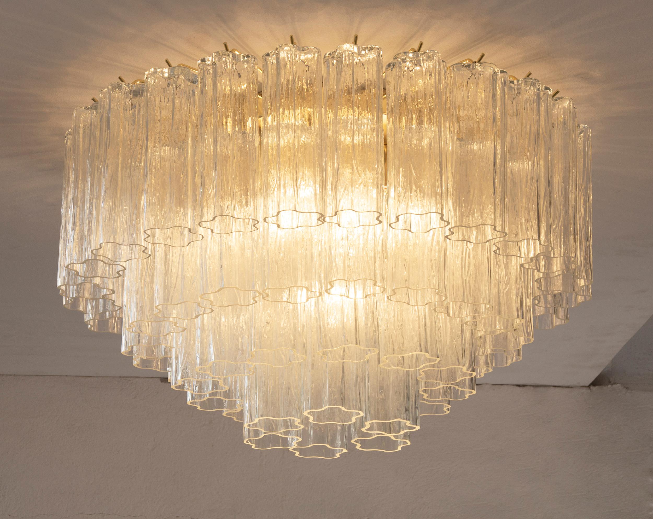 Grande lampadario plafoniera con pendagli in vetro di Murano ispirato al mid-century italiano

Direttamente dalla fonte:
Non siamo semplici rivenditori, ma produttori diretti! Situati vicino a Venezia, nel cuore dell'industria vetraria di Murano,