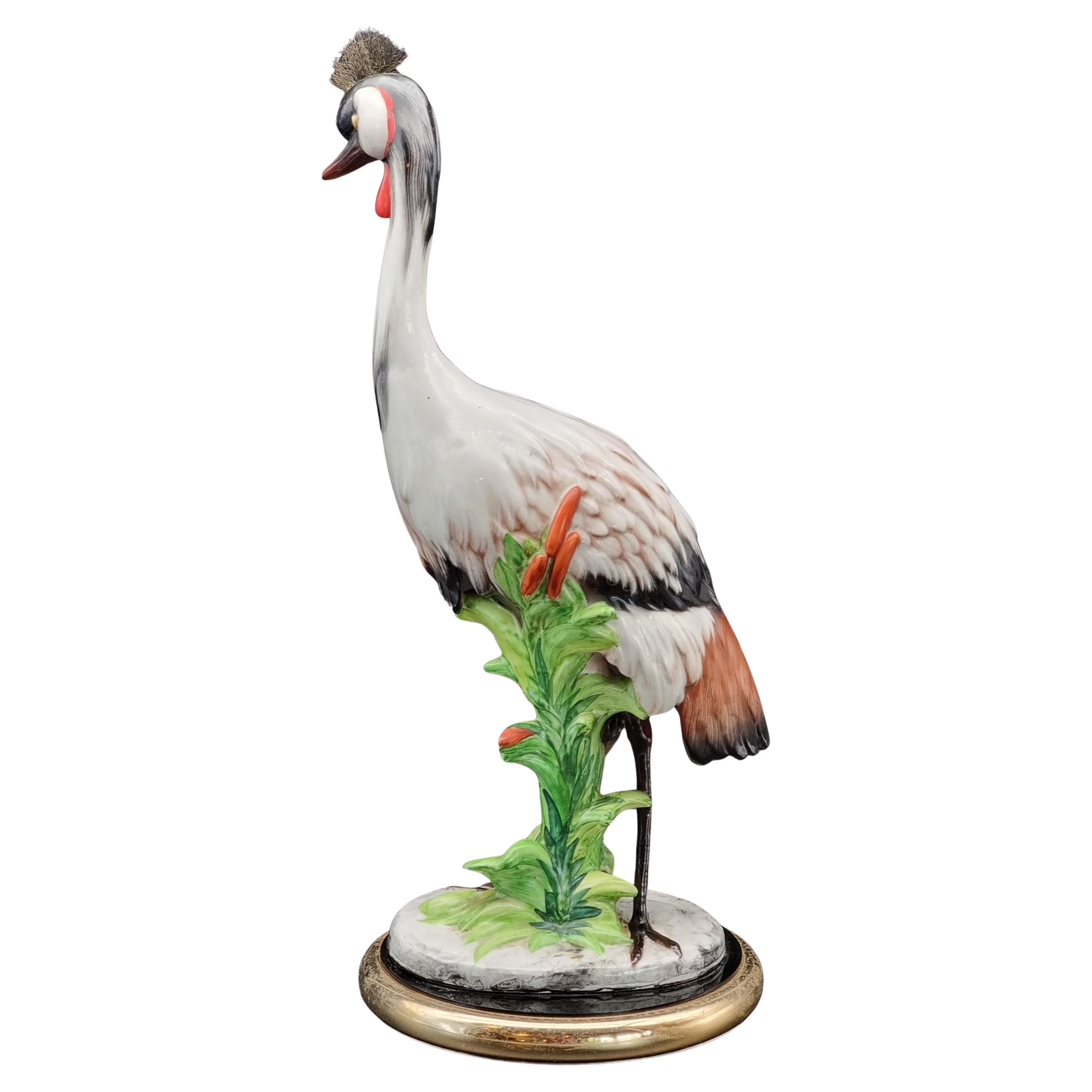 Gran escultura de cerámica vidriada que representa una grulla coronada en venta