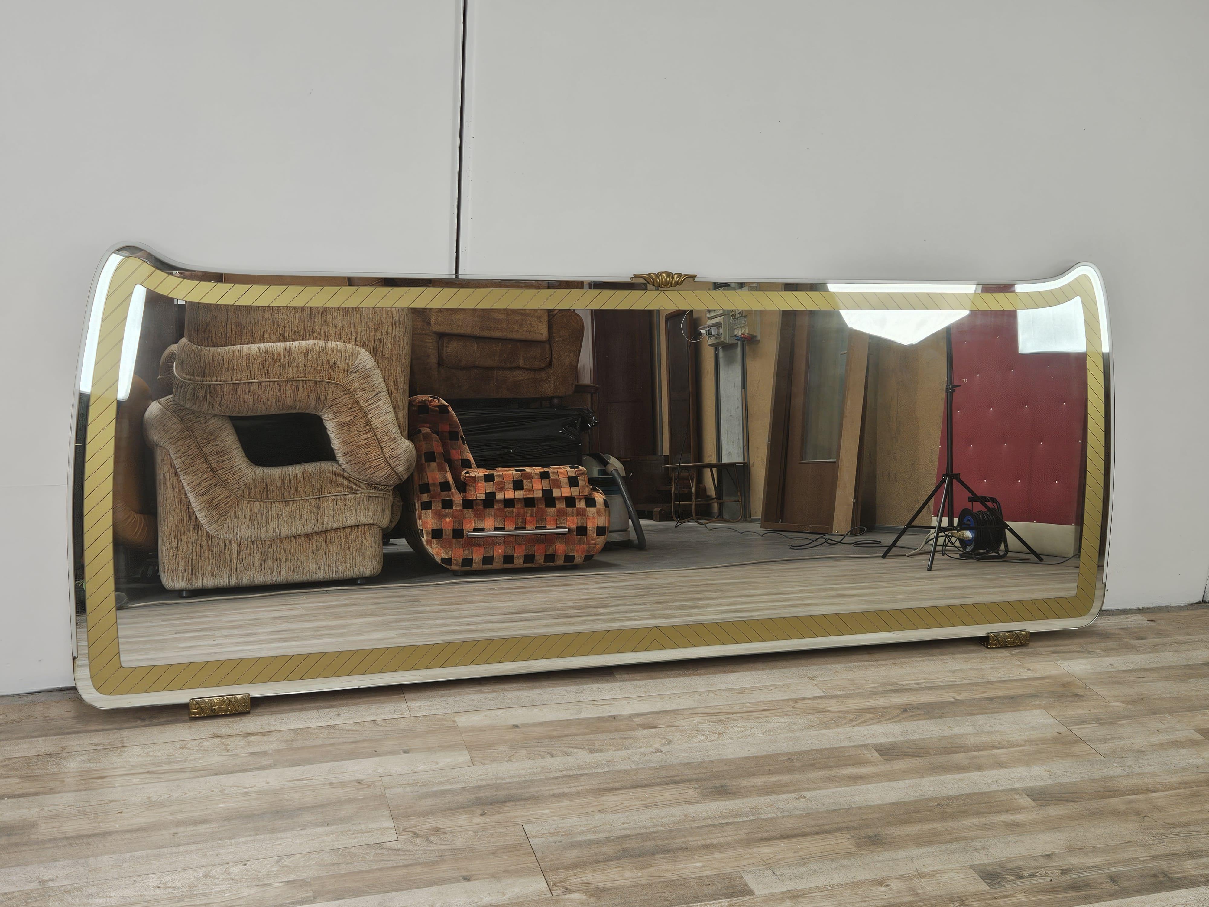 Immense miroir italien des années 1970 avec dos en bois et structure décorée de trois supports en laiton.

Le miroir provient d'un buffet et peut être utilisé en l'adossant à un mur ou à un meuble.

Très distinctif et d'un design moderne et