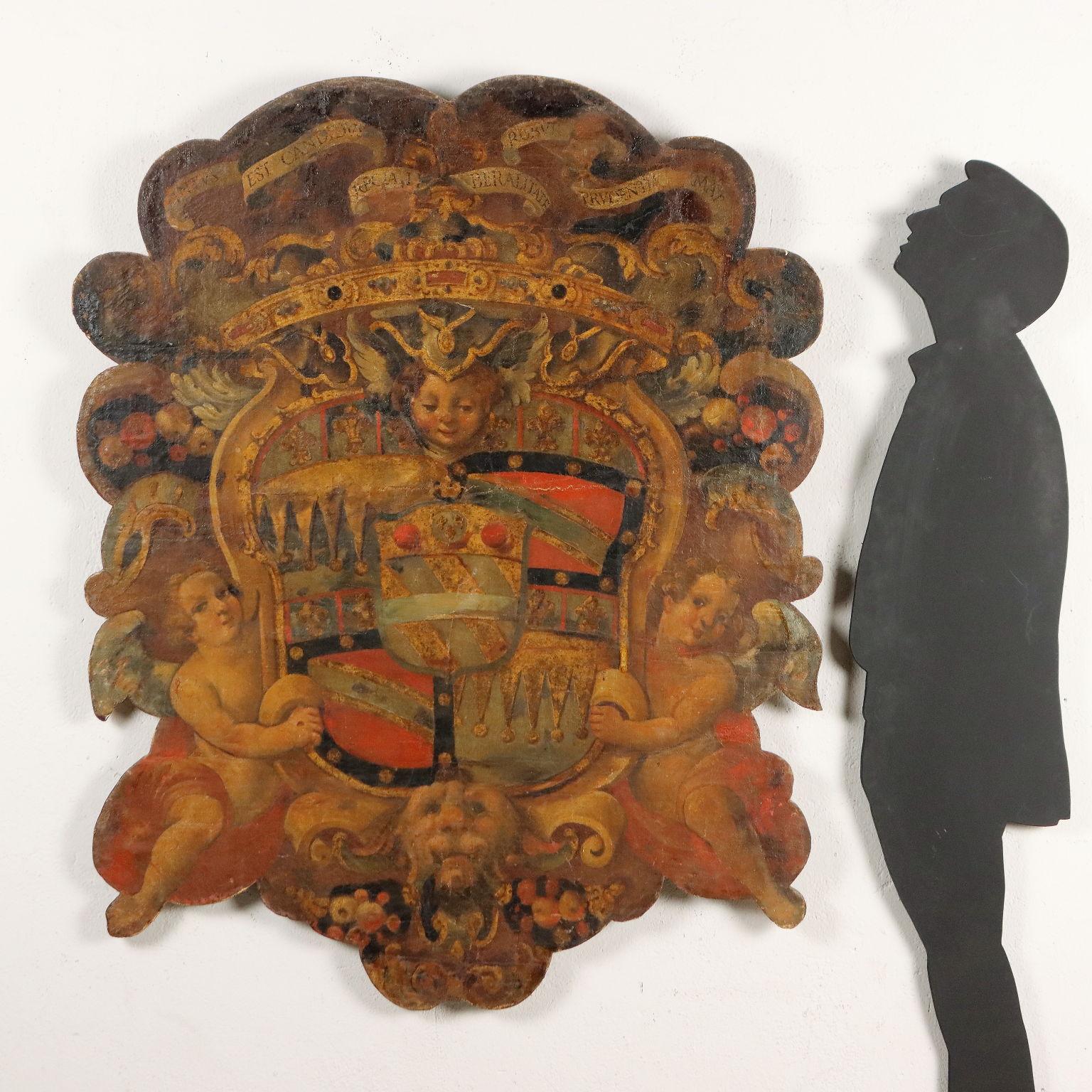 Large aristocratic coat of arms placed within crumpled, symmetrically unfolding, made of polychromatically painted and partially gilded wood. The frame is decorated with scrolls and festoons of fruit, while a ribbon unravels at the top bearing the