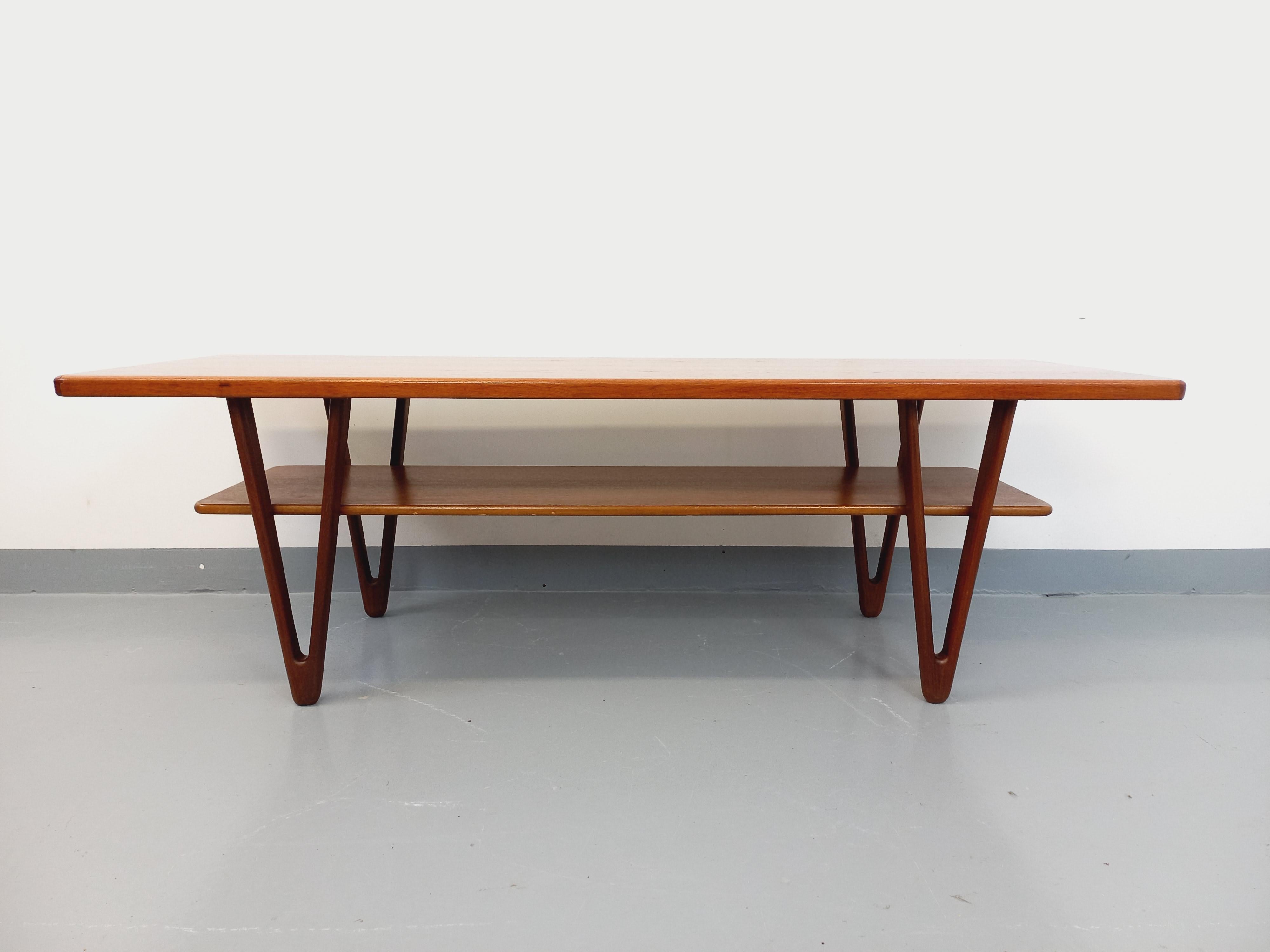 Grande table basse scandinave vintage des années 50, en teck, design danois de Kurt Østervig avec grand plateau supérieur et plateau inférieur porte-revue, superbes pieds en fuseaux, très bon état général avec quelques signes du temps qui passe.
Ref