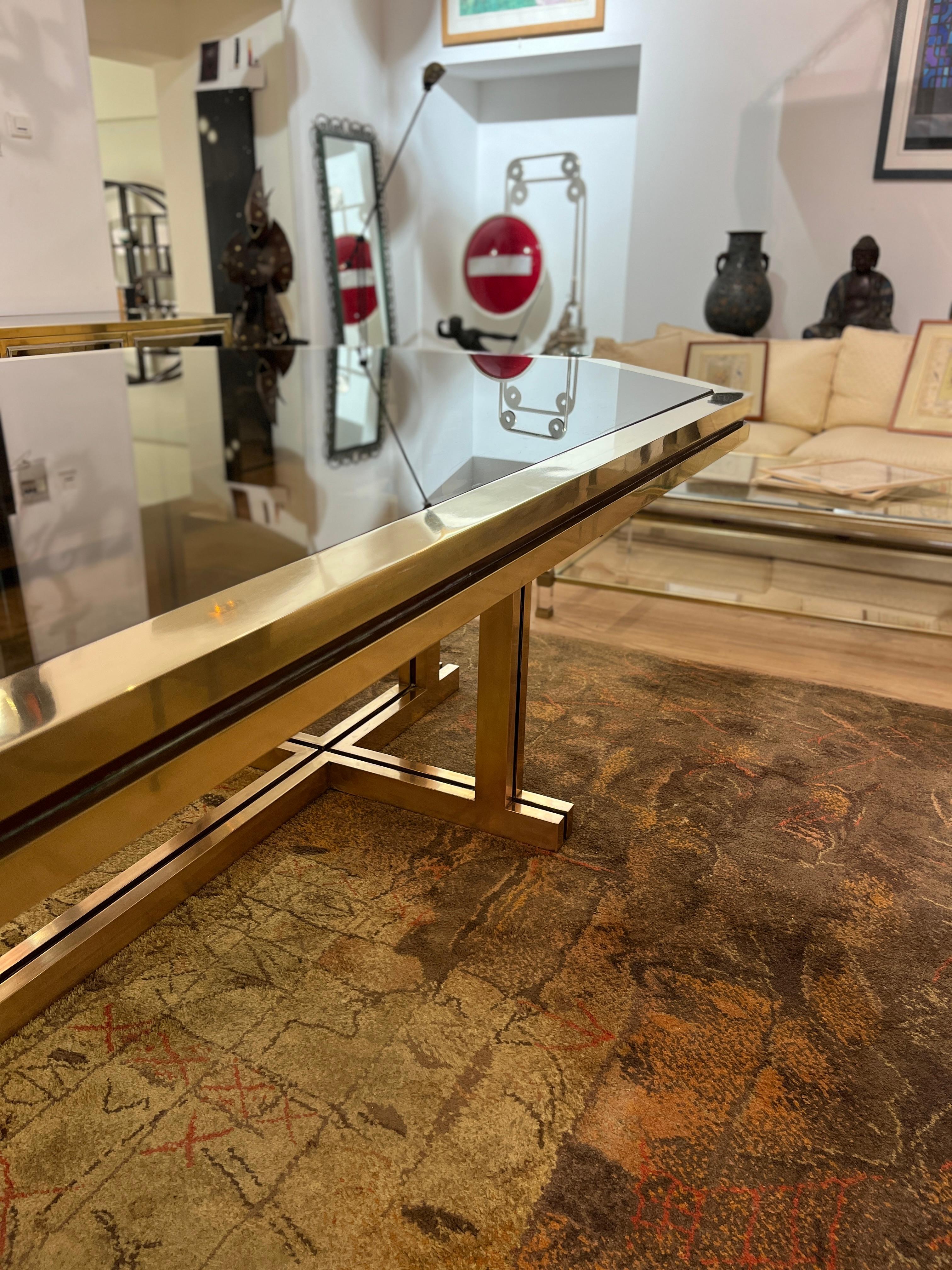 Superbe grande table hexagonale de salle à manger verre fumée et laiton réalisée sur commande spéciale par la Maison Jansen au milieu des années 70. Cette superbe table sera la pièce maîtresse de votre salle à manger, et se mariera aussi bien avec