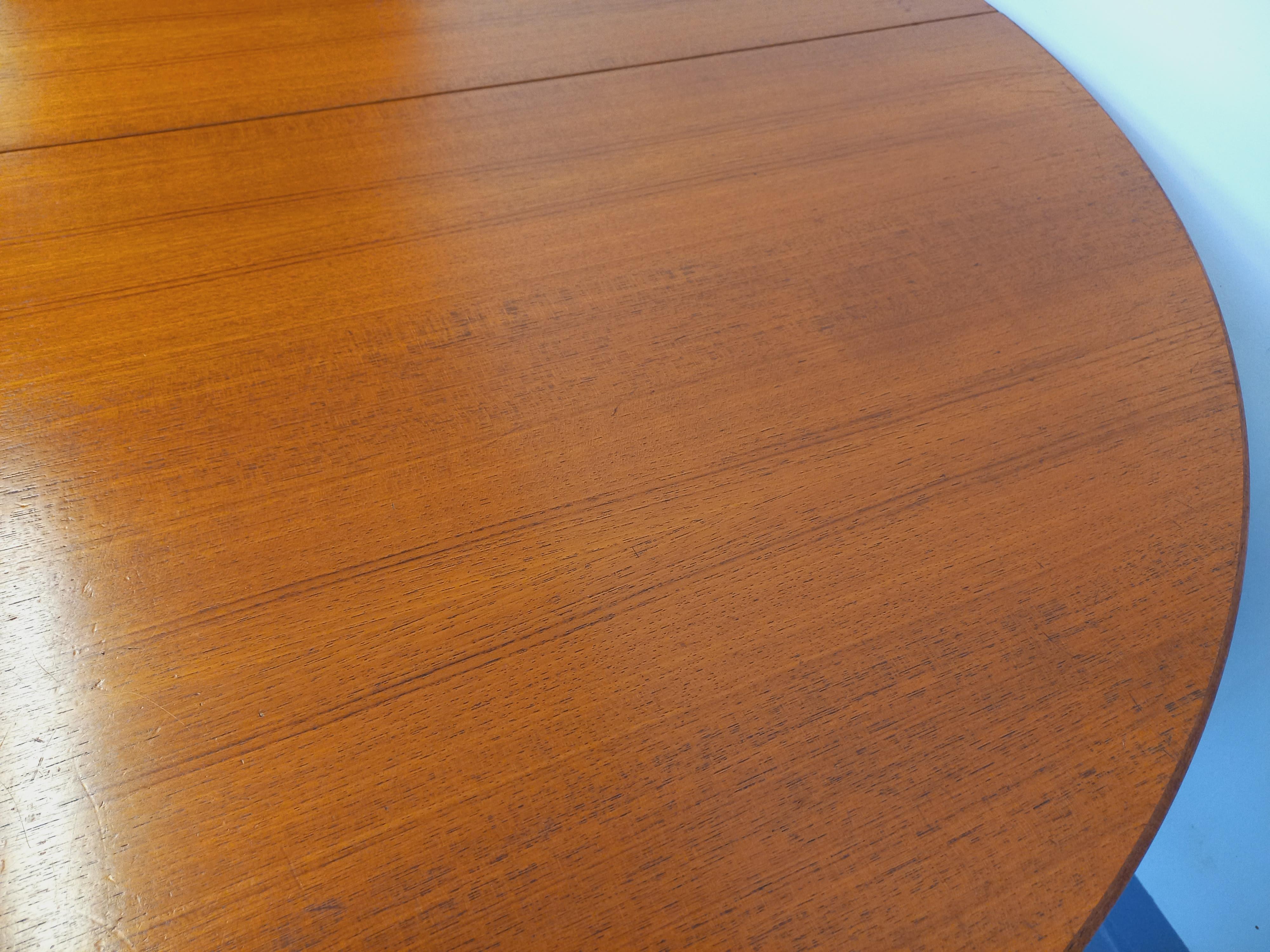 Grande table ronde scandinave vintage des années 50 60, en teck, avec deux rallonges centrales papillon intégrées, très joli plateau avec bandeau large en teck, pieds compas, bon état général avec des marques d'usage sur le plateau.
Ref 241