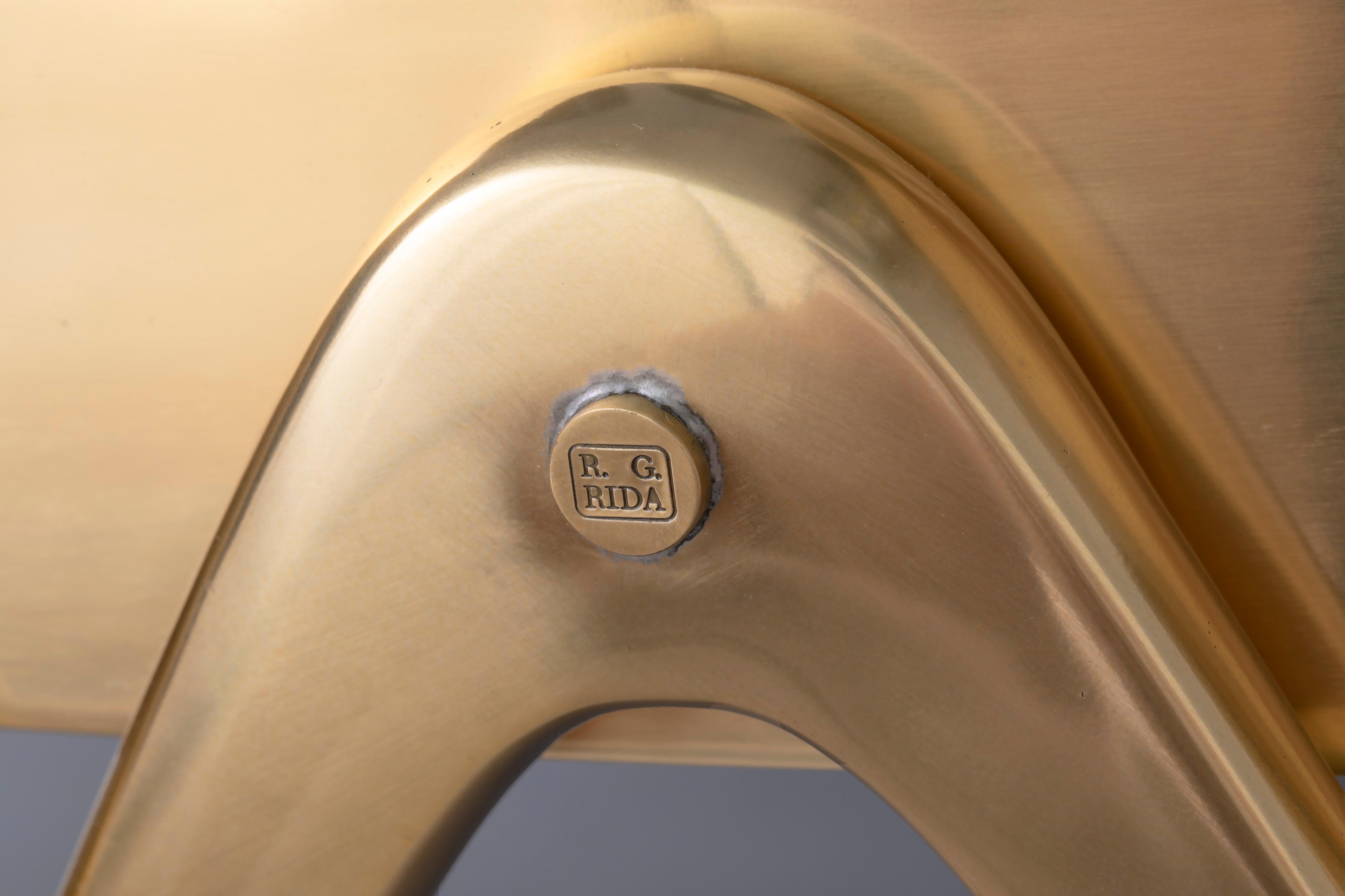 Table basse COMPASSO 120 
Elégante table basse constituée d'un corps en laiton et bronze composé de 27 pieds en bronze en forme de compas, tous reliés par un épais anneau en laiton.  Une coupe en verre spécialement courbée à la main, mesurant 120 cm