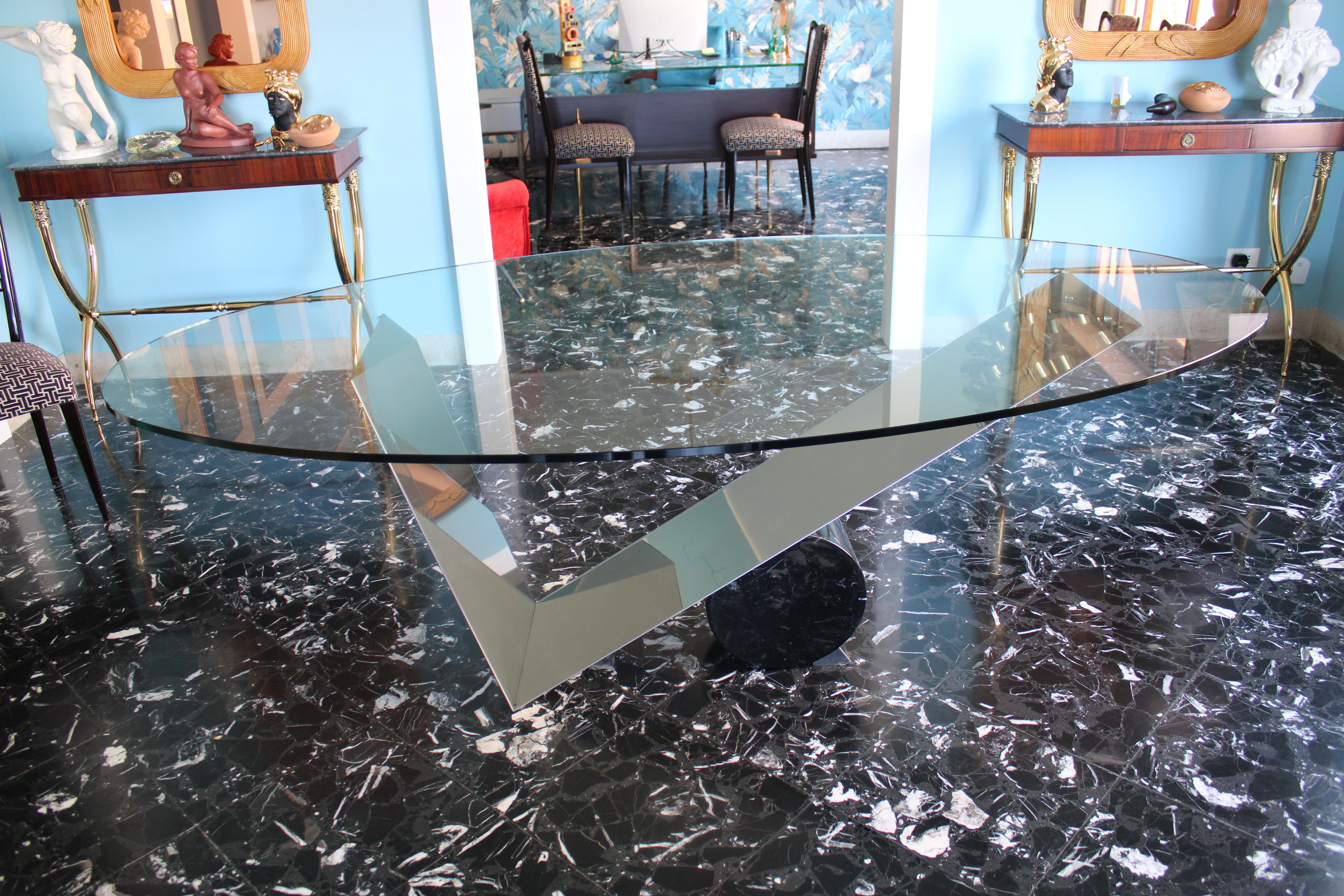 Oval table with glass plate and shaped steel support and black Tarquinia marble.
