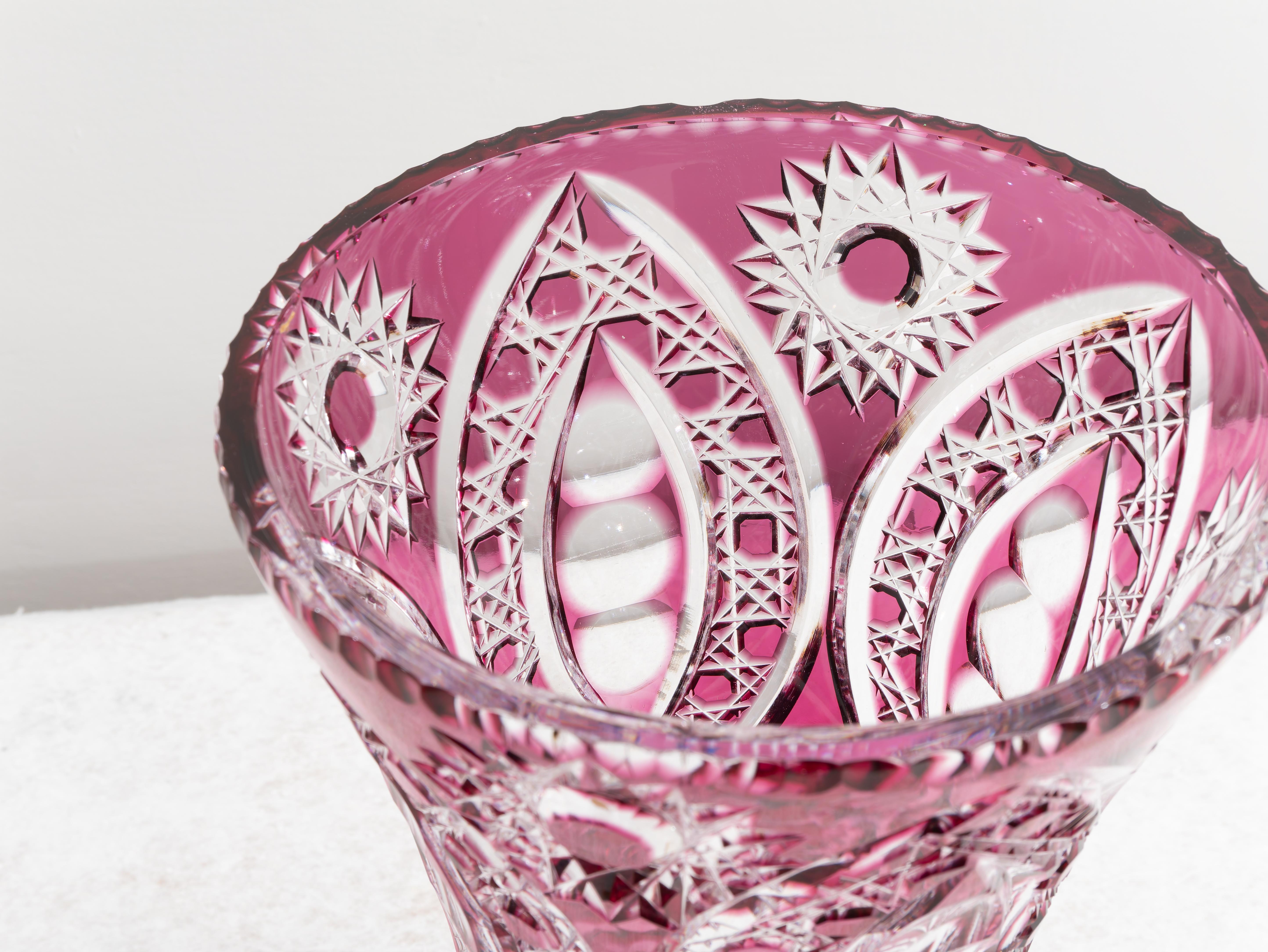 Gran jarrón bohemio de cristal fucsia, años 40. 
Extraordinario jarrón de cristal color fucsia de estilo bohemio con decoración especial tallada. Su forma, muy colorida, añade brillo a este extraordinario objeto y se adapta a cualquier tipo de