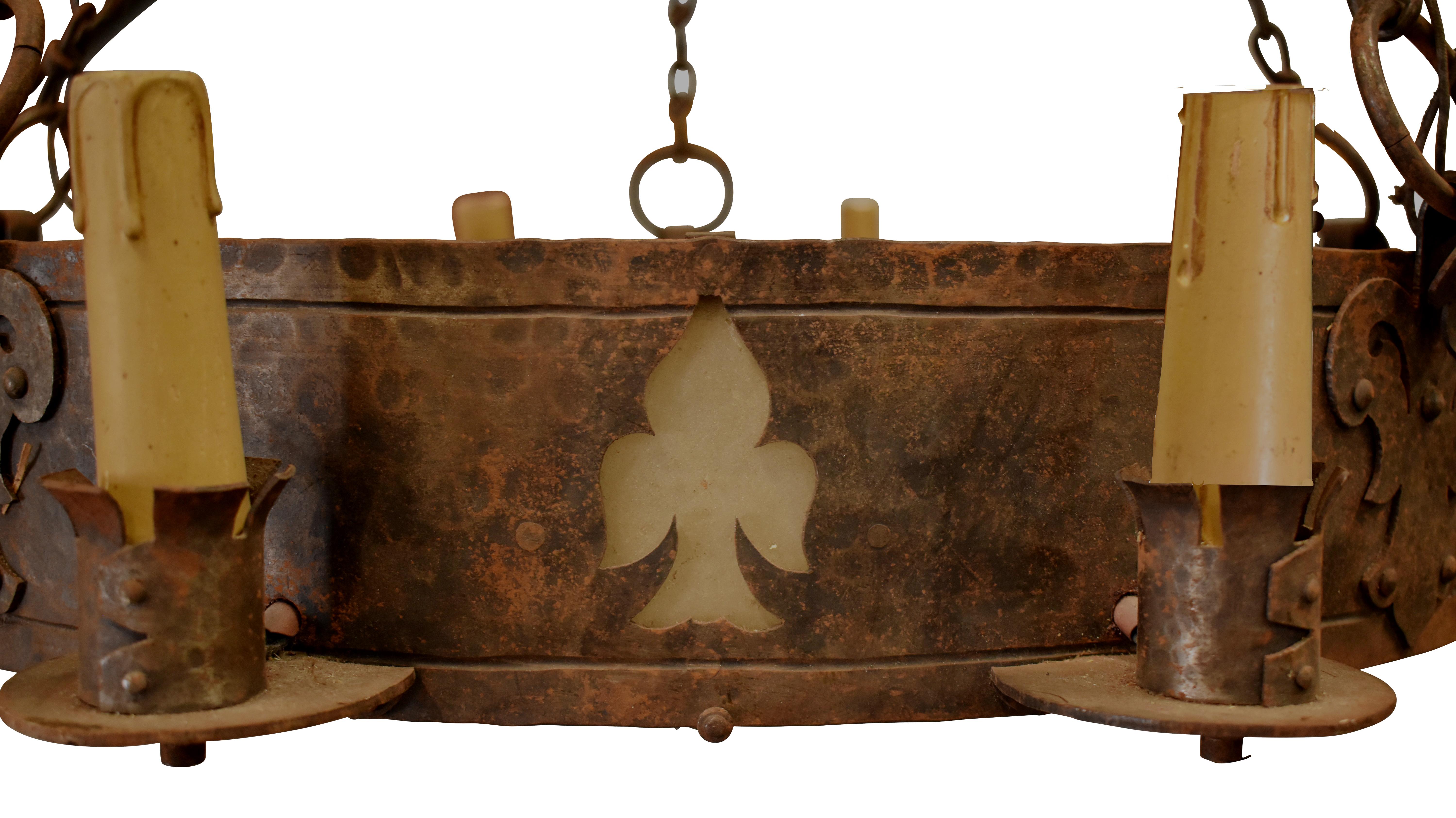 Large vintage hand-forged iron chandelier brings light and a strong statement to a room. Fleur de Lis cutouts and bracket details give added interest. European wiring – will need to be rewired.

This chandelier could be 19th Century but marked it