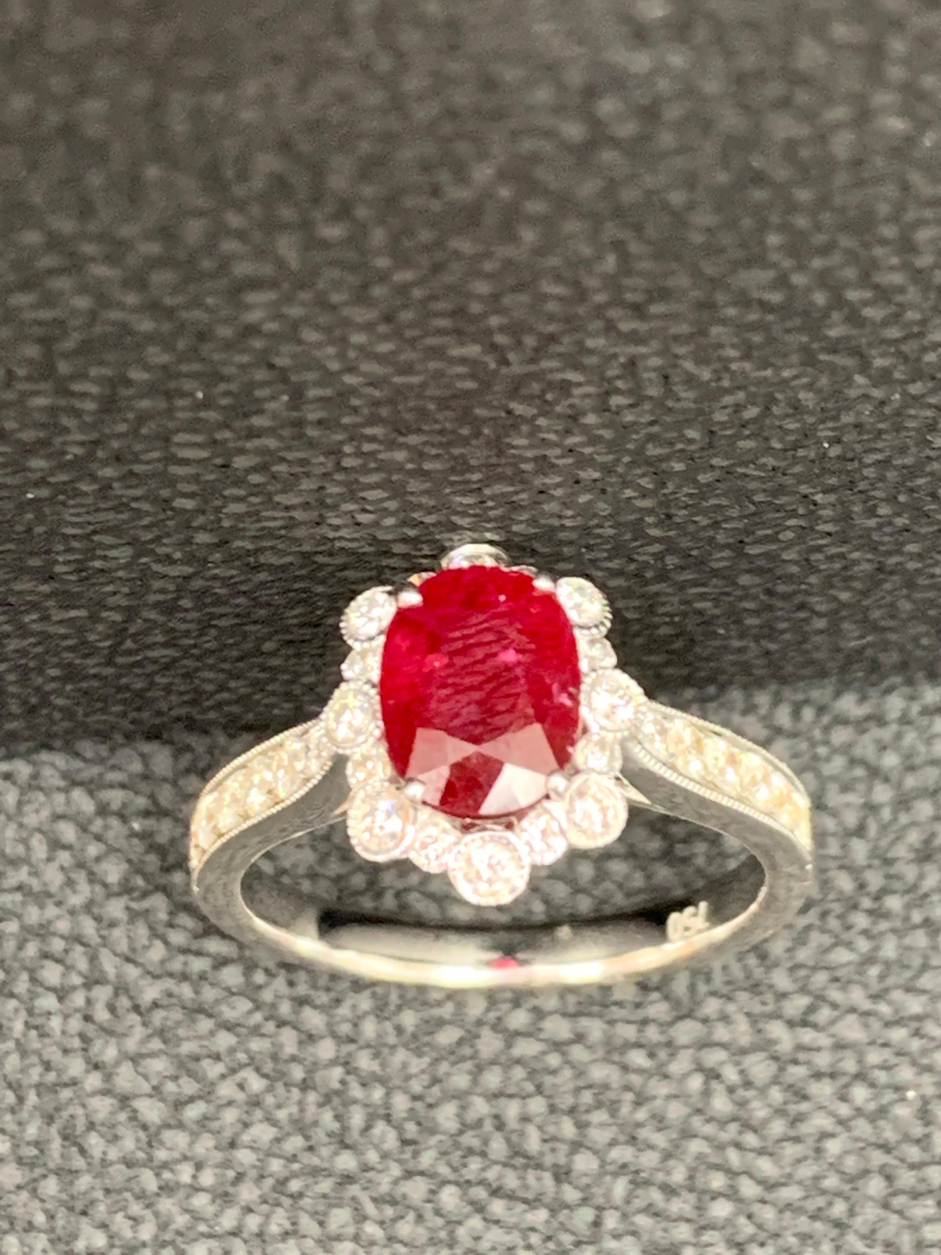 A vibrant and colorful engagement ring that features a 0.83 carat  oval cut ruby surrounded by Diamonds all over. The Ruby is set on a 4 prong white gold basket attached to a 18 karat white gold shank. Round cut brilliant diamonds weigh 0.44 carat
