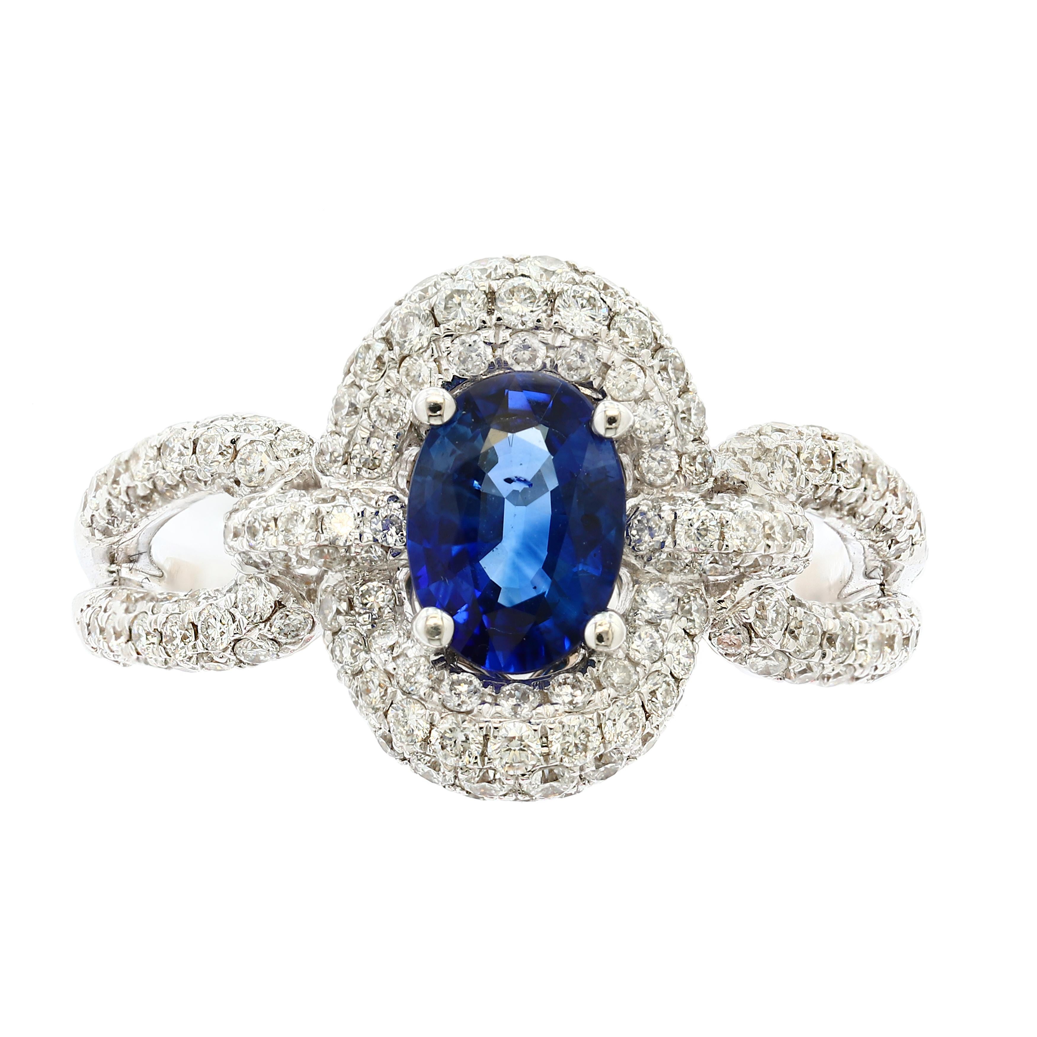 A vibrant 0.94 carat oval cut blue sapphire takes center stage as it elegantly contrasts the sparkling diamonds around it. Set in a chic split shank setting accented with more brilliant diamonds. 
182 Accent diamonds weigh 0.94 carats total. Made in