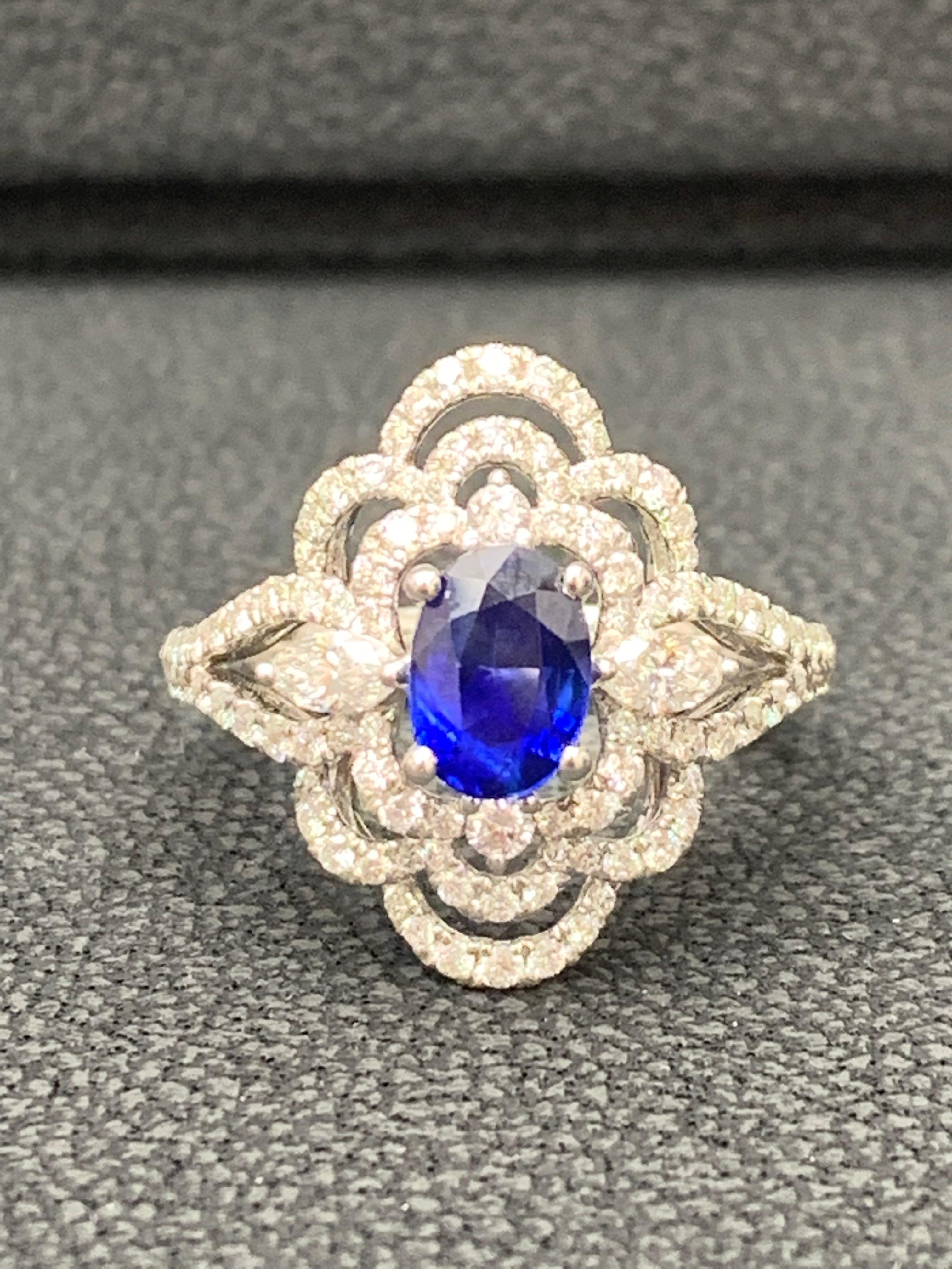 A unique flower engagement ring showcasing  0.97 carat color-rich blue sapphire, surrounded by round brilliant diamonds in a open-work floral motif. Set in an 18 karat white gold mounting accented with diamonds. Diamonds weigh 0.78 carats