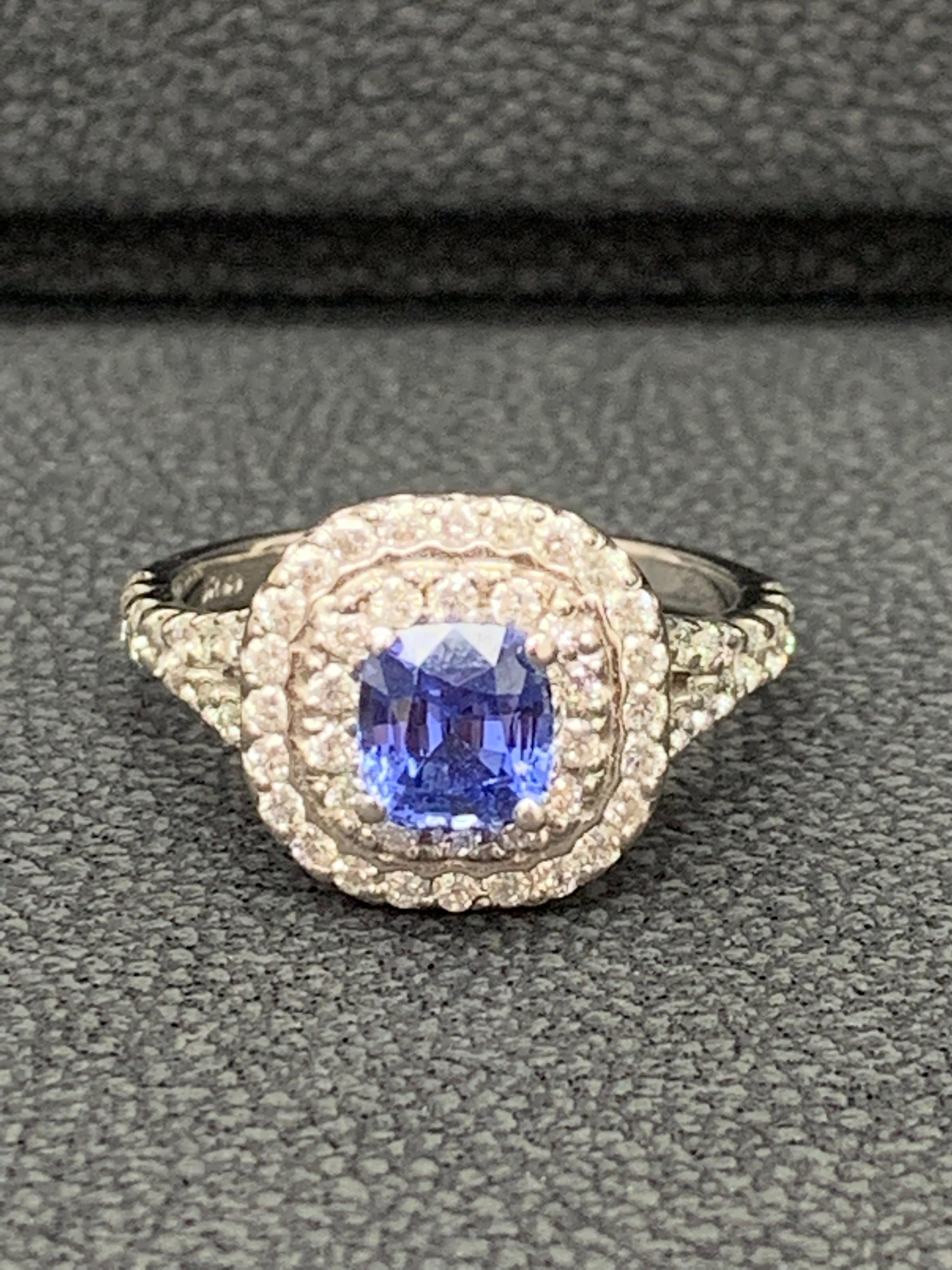 Showcasing a 1.20 carat cushion cut blue sapphire. BLUE color with no indications of heat treatment. Surrounding the sapphire are 2  rows of round brilliant diamonds, in a diamond encrusted mounting made in 14K white gold. Accent diamonds weigh 0.88