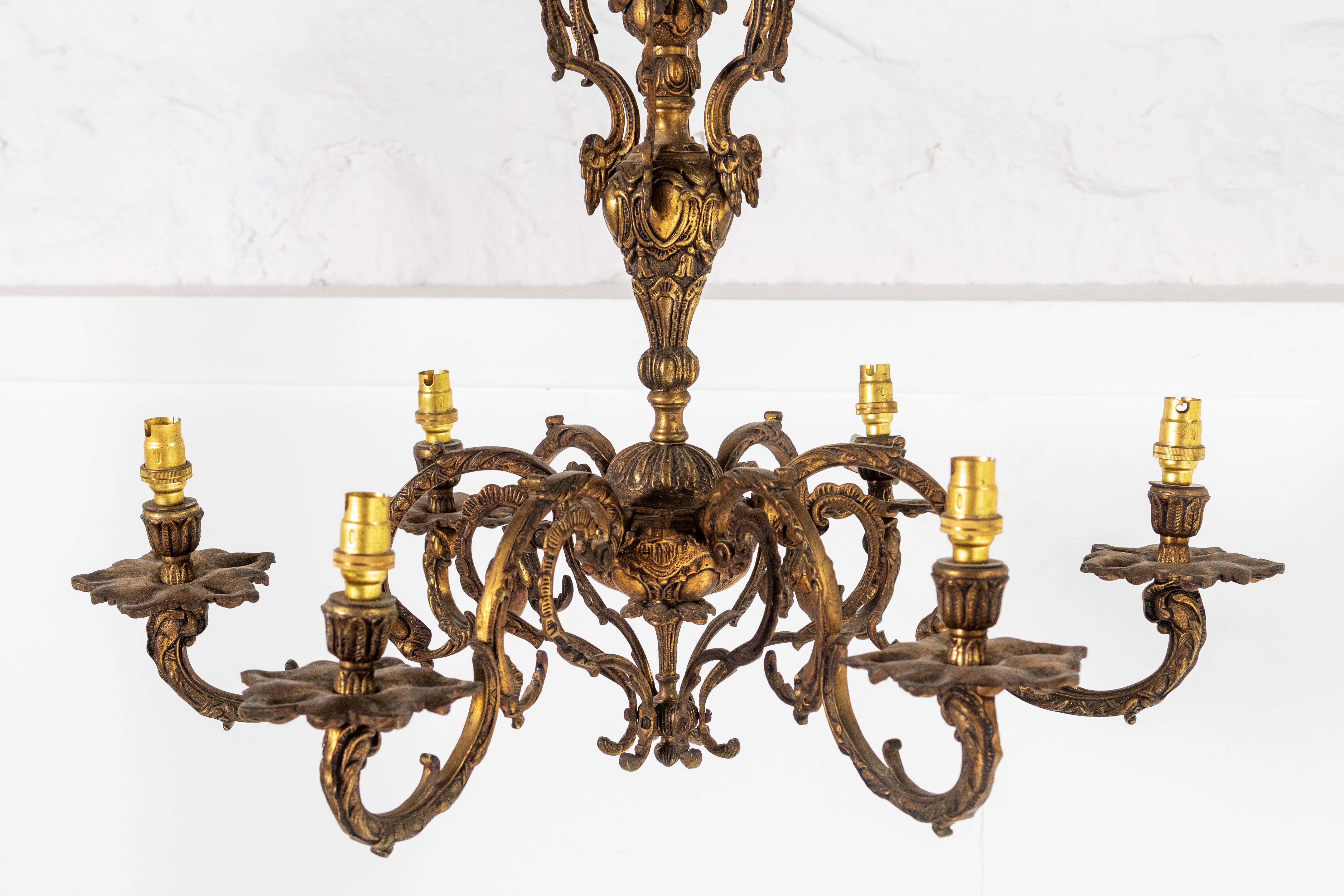 A superb French gilded cast bronze 6 arm chandelier, ornate scrolling arms with leaf bobeche drip pans and bulbous candle sconces, issuing from an ornate foliated central column with scrolling leaf canopy.
A beautiful piece, the original faded