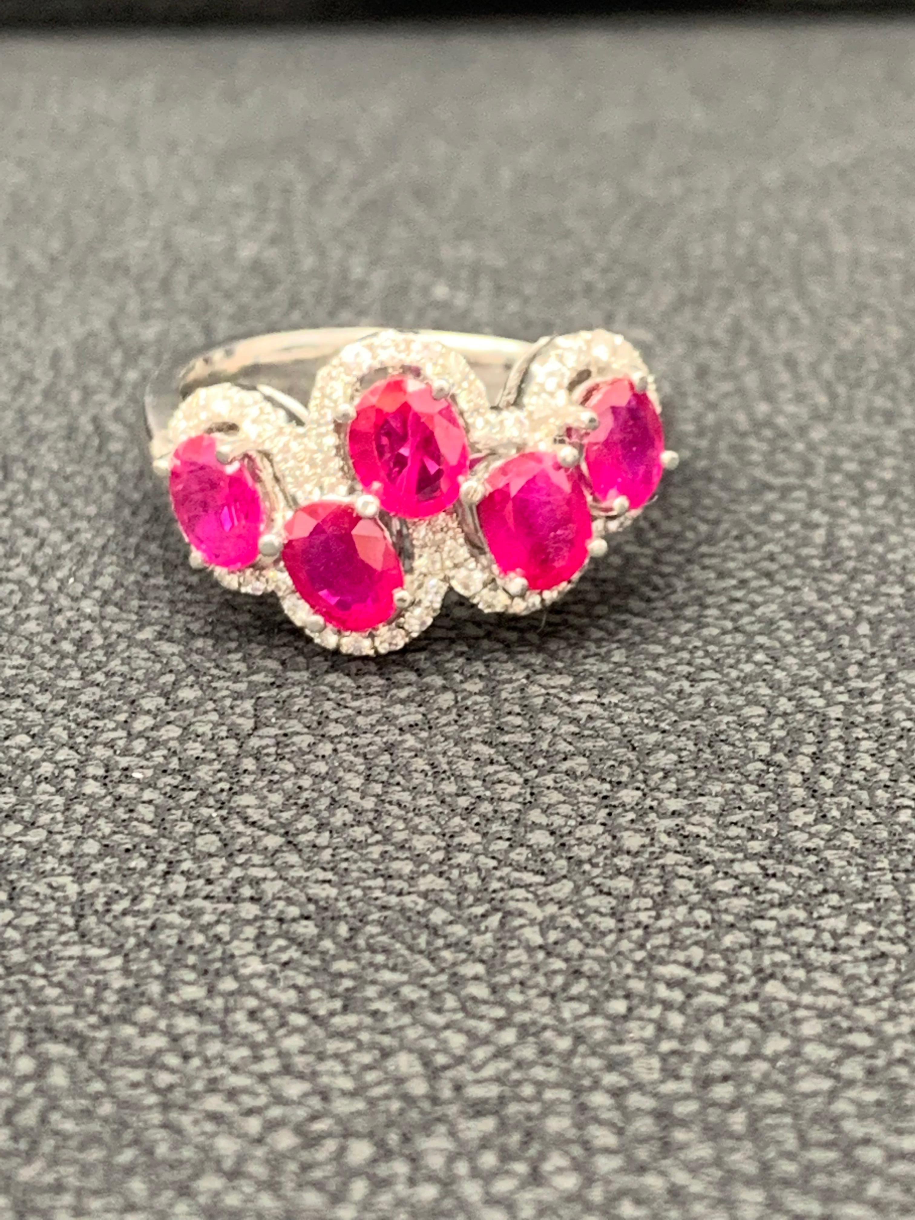Beautiful ring set with 5 oval cut rubies weighing 2.25 carats total. Asymmetrically set rubies are  urrounded by a single row of round cut melee diamonds weighing 0.31 carats total. Set in 18k white gold. 

Size 6.5 US (Sizable). One of a Kind 