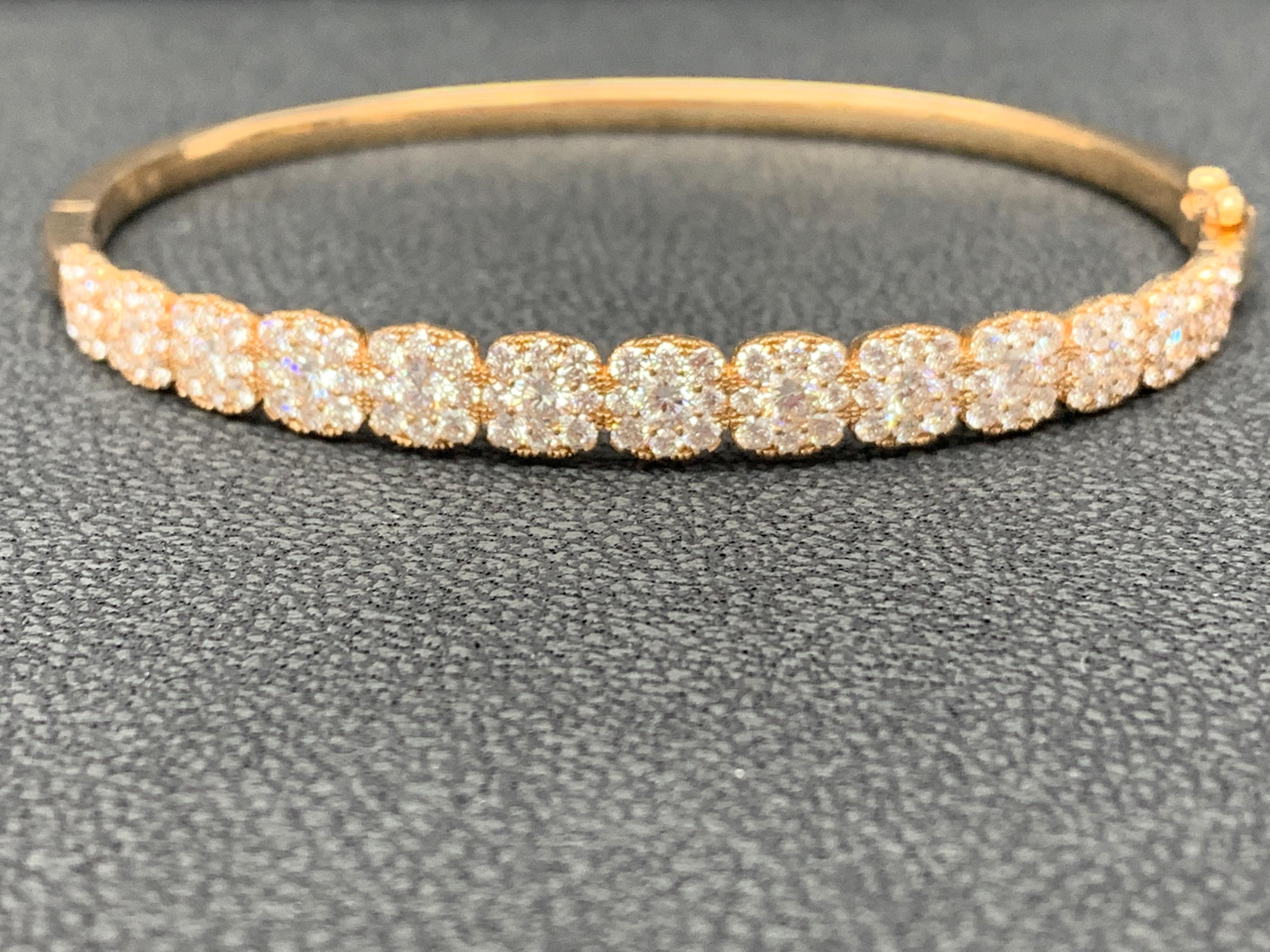 Sparkle in the spotlight with this diamond bangle bracelet. Features 13 center  round diamonds weighing 2.34 carat total. Each elegantly surrounded by a row of smaller Diamonds set in an 18k rose gold basket. Total Diamonds weigh 2.49 carats . A
