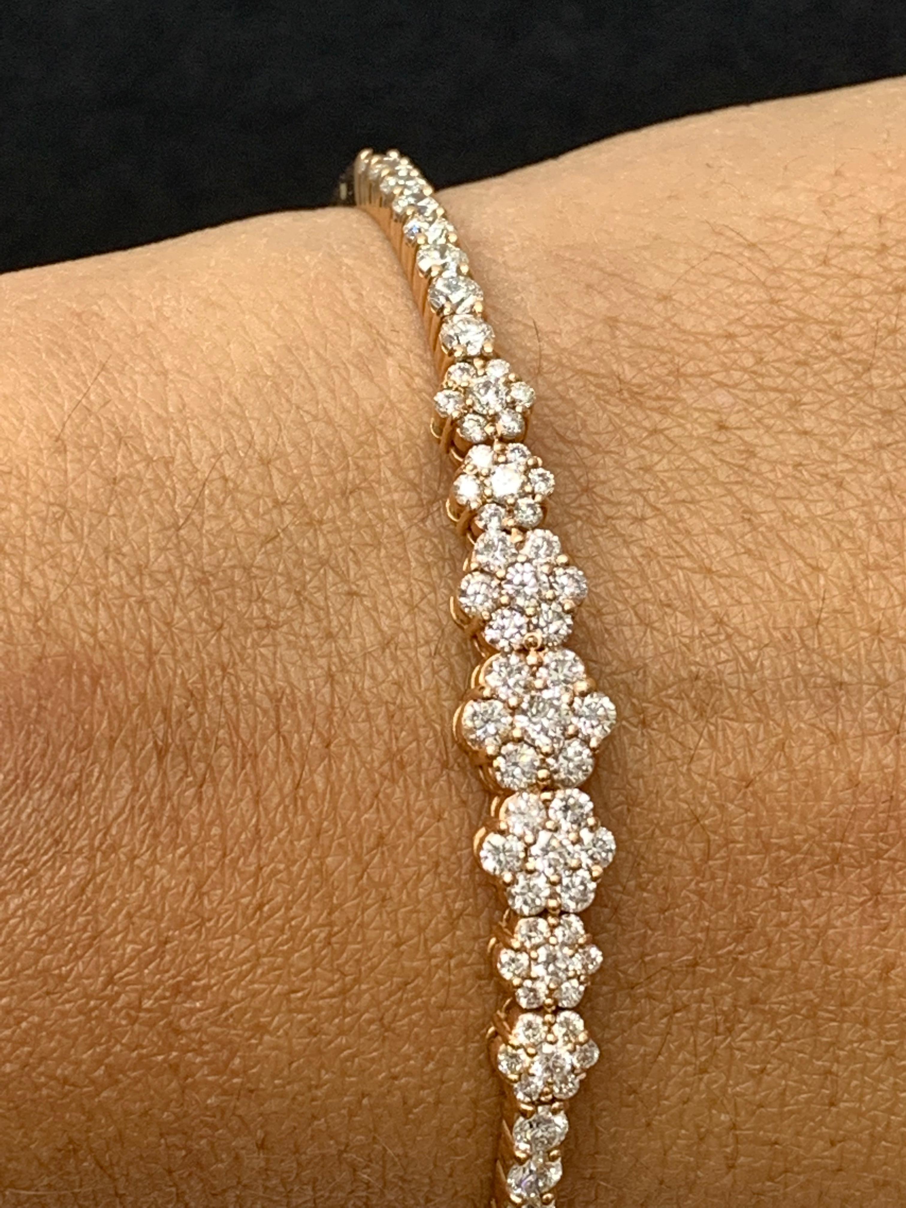 Sparkle in the spotlight with this diamond bangle bracelet. Brilliant cut Diamond flowers graduating towards the center weigh 2.54 carat in total. Set in an 14k rose gold basket. A hinged design bracelet for easy wear and removal. 

All diamonds are