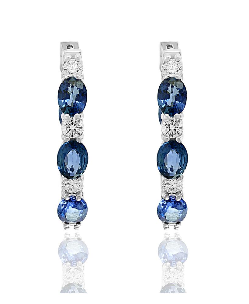 A stylish and versatile style hoop earrings showcasing oval cut blue sapphires weighing 5.54 carats total, channel set in a diamond encrusted 18 karat white gold mounting. Diamonds weigh 0.93 carats total.

All diamonds are GH color SI1