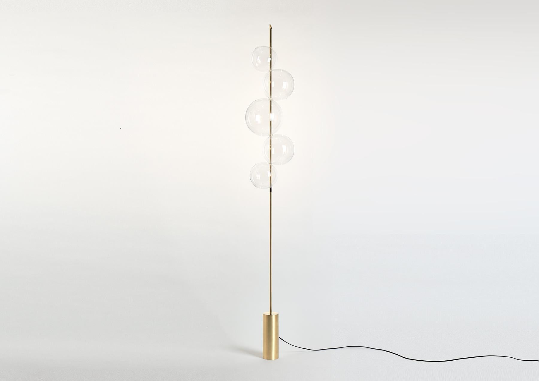 Inspired by pieces of Hail, Grandine Five lights Floor / Standing Lamp is composed of five touching glass orbs, which are positioned to give the impression of balls of ice that have melted together to form one solid, transparent piece. 
This lamp