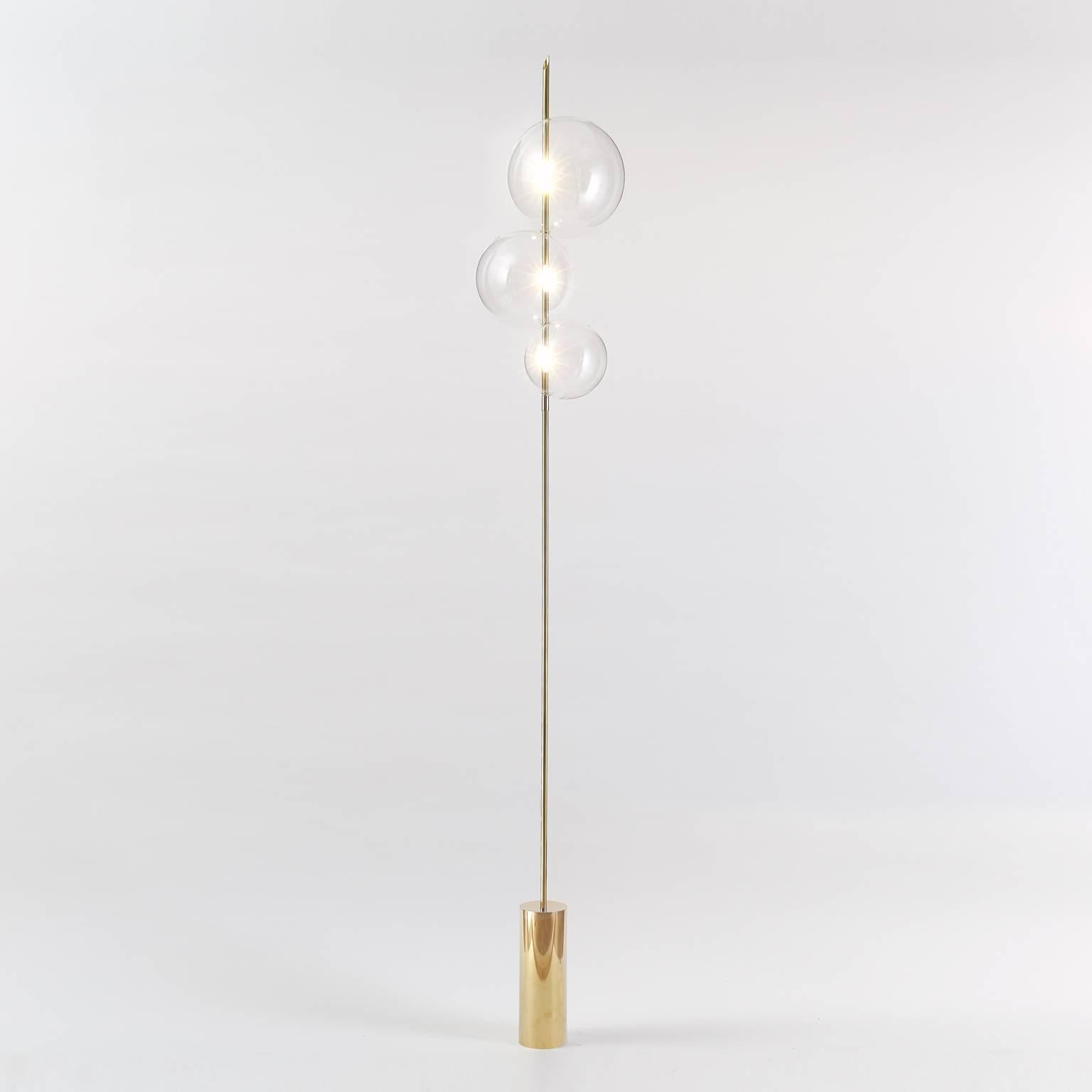 Grandine Three Lights Mirrored Brass ist eine minimalistische, zeitgenössische Stehleuchte, die aus drei sich berührenden, mundgeblasenen Glaskugeln besteht, die so angeordnet sind, dass sie den Eindruck von Eiskugeln erwecken, die