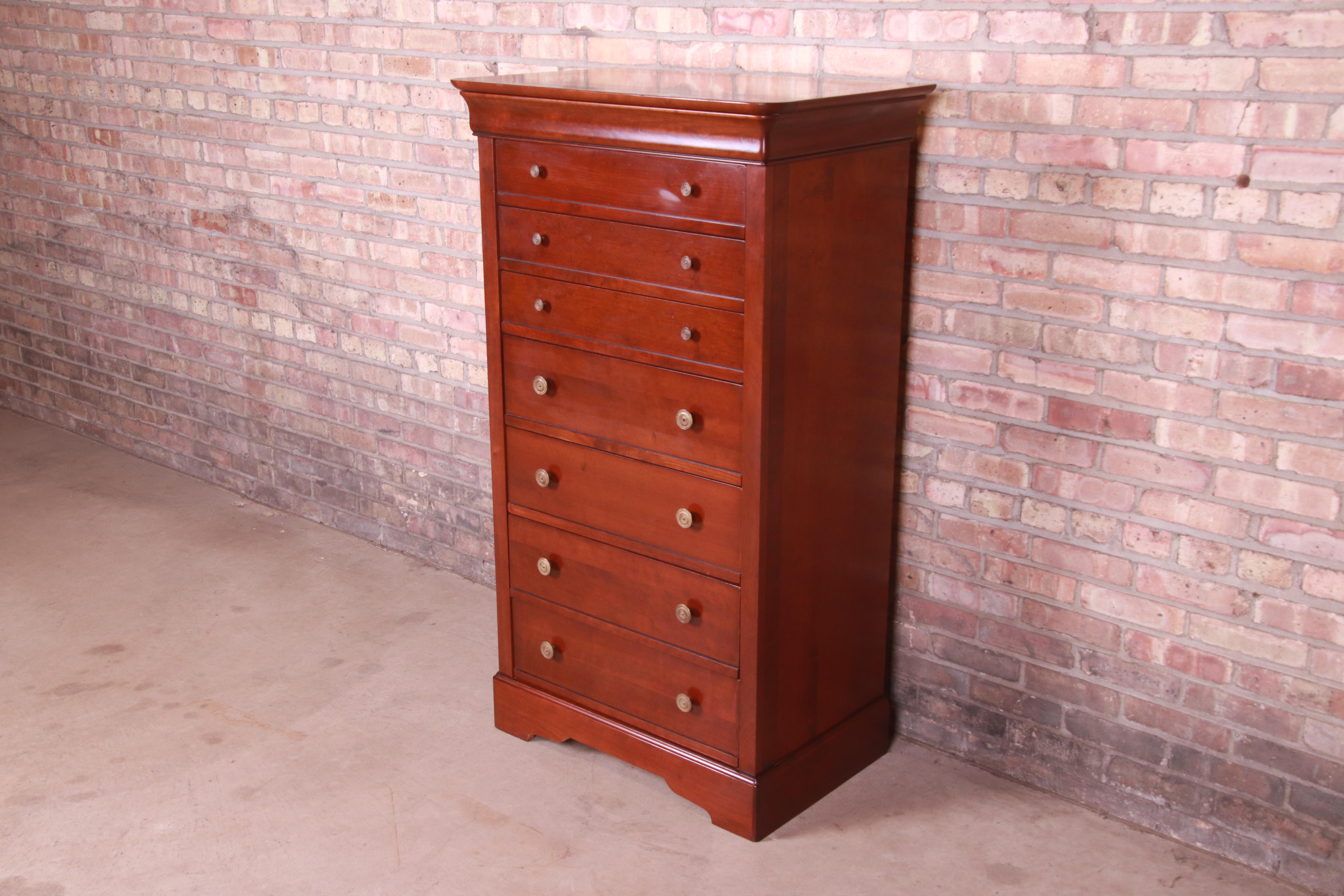 A gorgeous French Louis Philippe style highboy dresser, lingerie chest, or semainier

By Grange

France, Circa late 20th century

Cherry wood, with original brass hardware.

Measures: 31.25