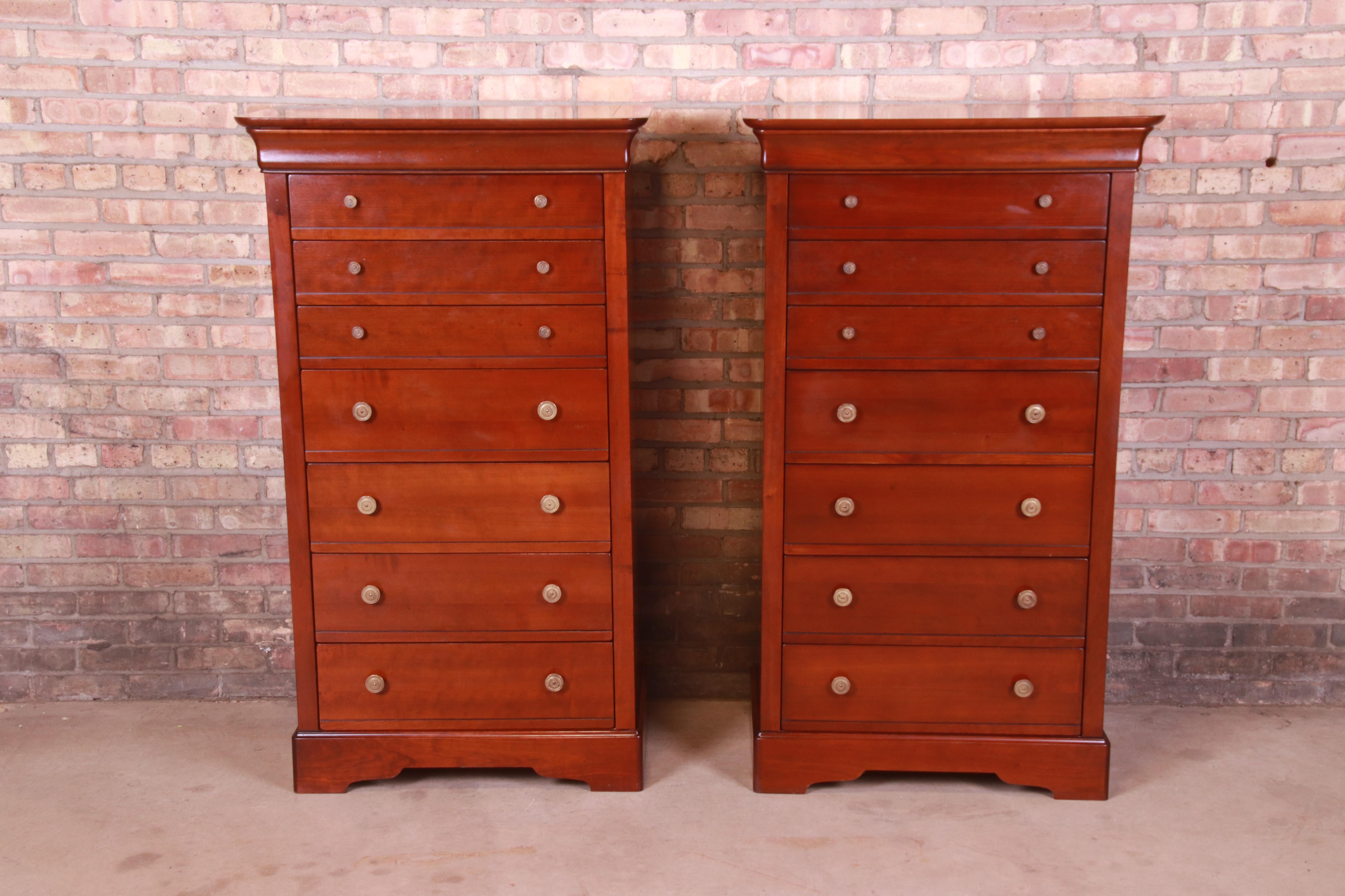 A gorgeous pair of French Louis Philippe style highboy dressers, lingerie chests, or semainiers

By Grange

France, Circa Late 20th Century

Cherry wood, with original brass hardware.

Measures: 31.25