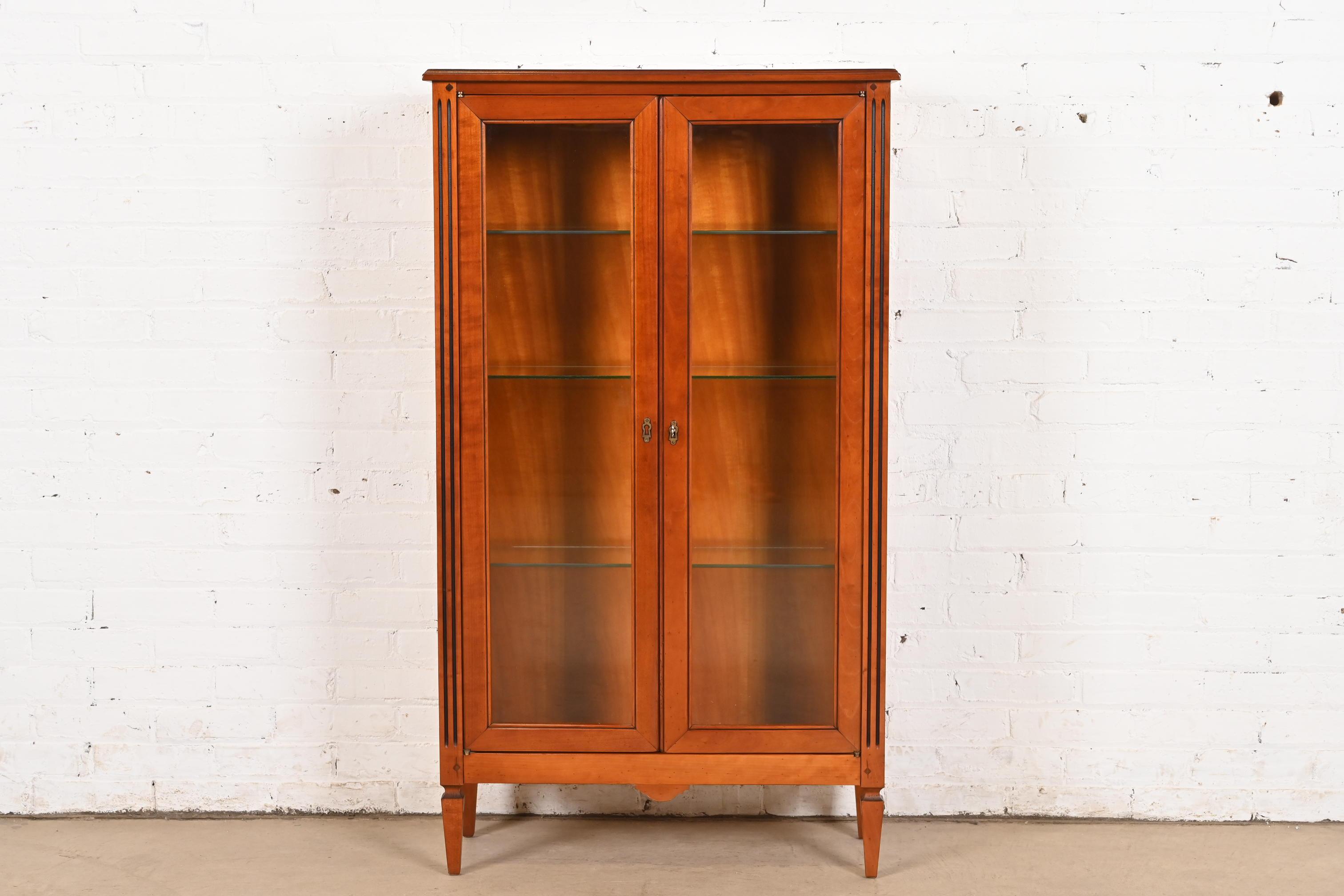 An exceptional French Regency Louis XVI style display cabinet or bookcase

By Grange

France, Circa Late 20th Century

Solid cherry wood, with brass hardware. Cabinet locks, and key is included.

Measures: 29