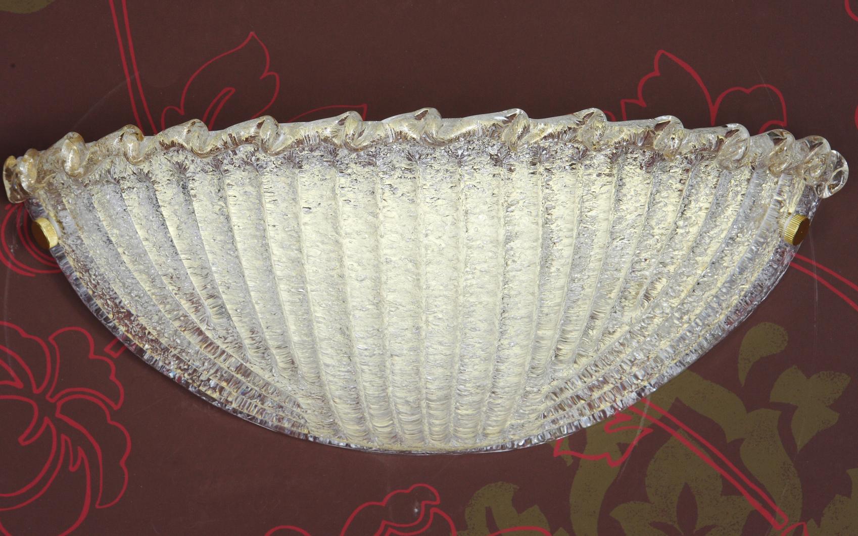 Italian wall light with a Murano glass shield hand blown in Graniglia technique to produce granular textured effect with gold flecks, mounted on gold plated finish frame / Made in Italy
Measures: Height 7 inches, width 16 inches, depth 6 inches
1