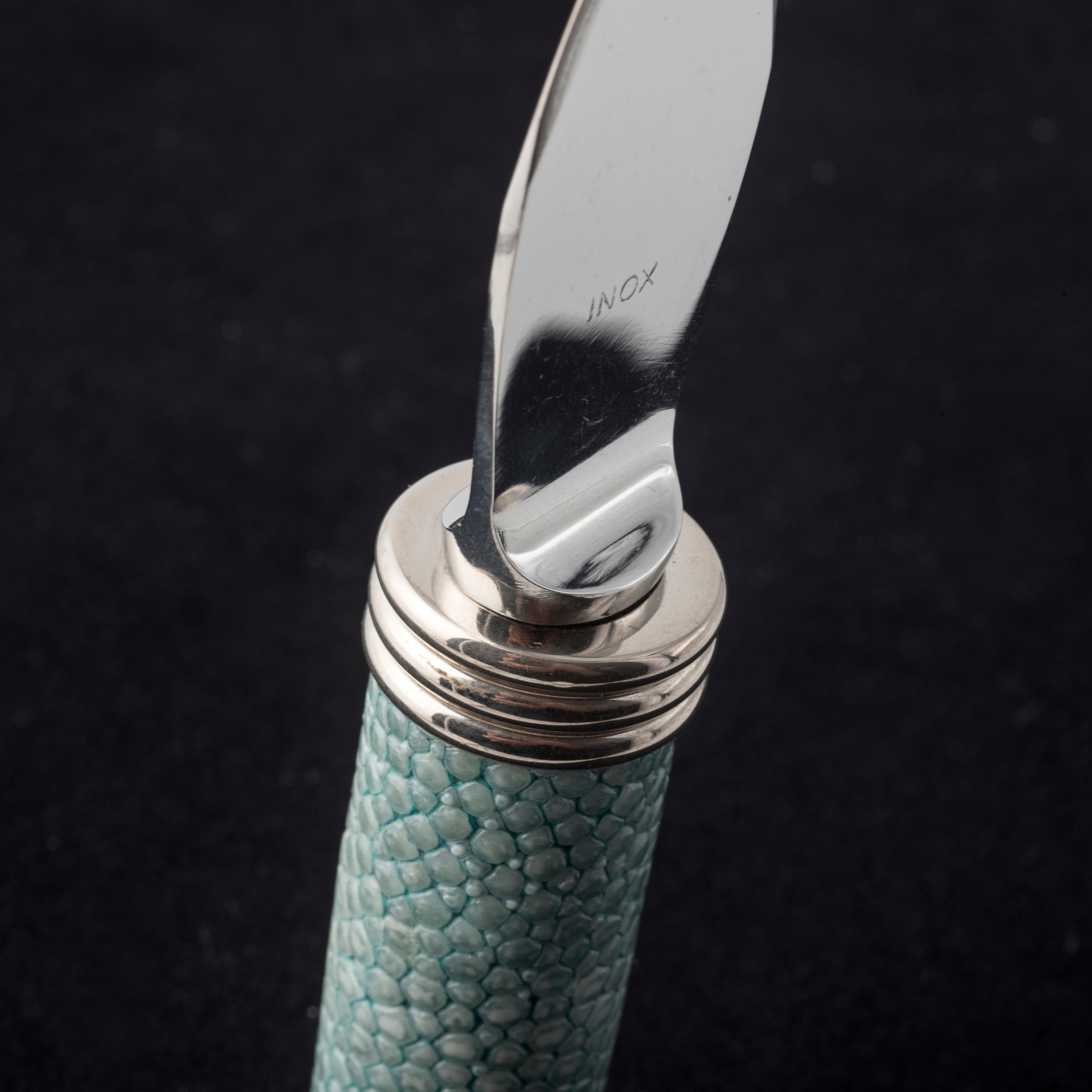 La decoración  mango en  piel de raya auténtica  verde brillante es la característica de este refinado  cuchillo  específico para queso en escamas.
Diseñado por Nino Basso,  este indispensable accesorio de mesa,  combina un diseño moderno  de  hoja