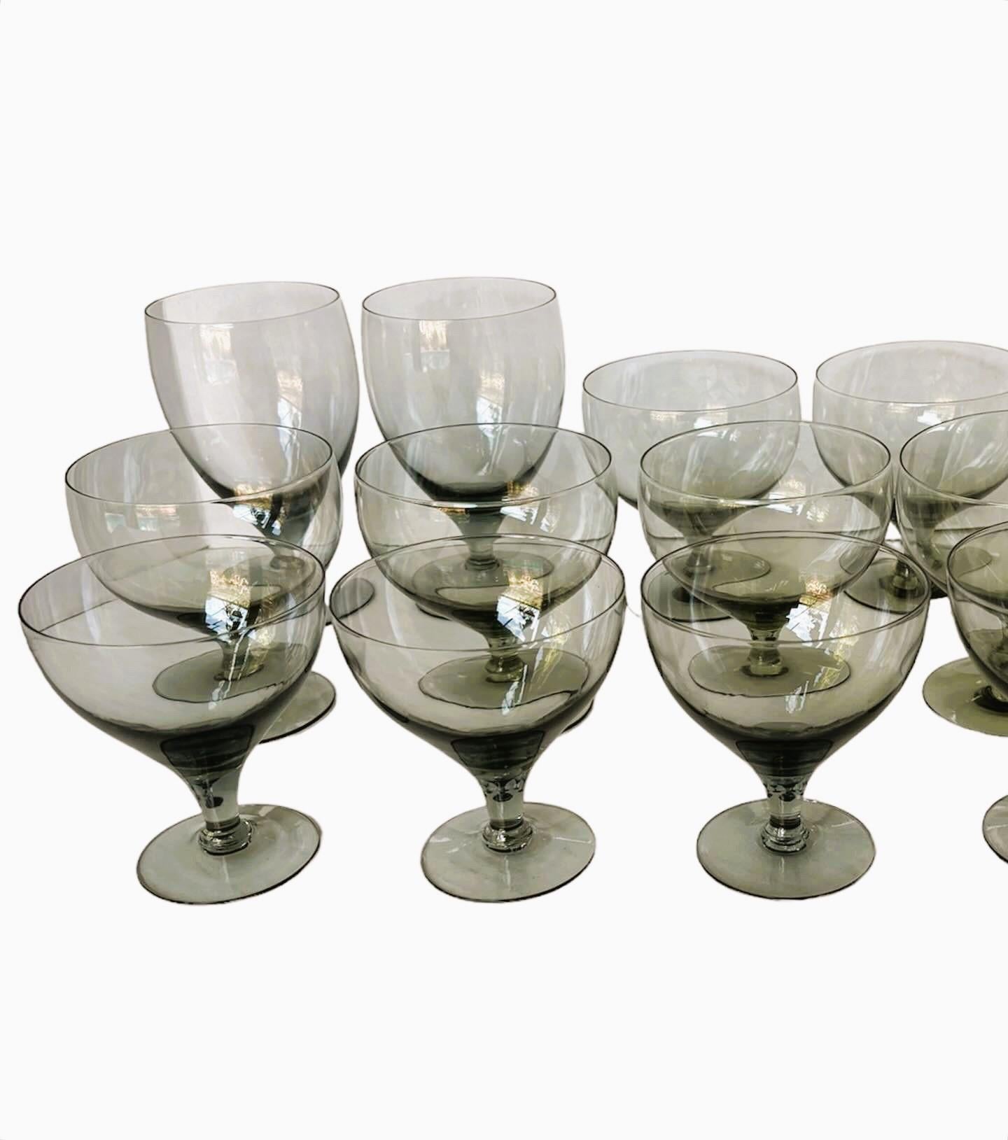 Mid Century Modern grouping of 15 American Modern tall goblets designed by Russel Wright and manufactured by Morgantown. Consisting of 15 Granite Gray stem glassware in three different sizes all in Very Good condition. Since the glasses were hand