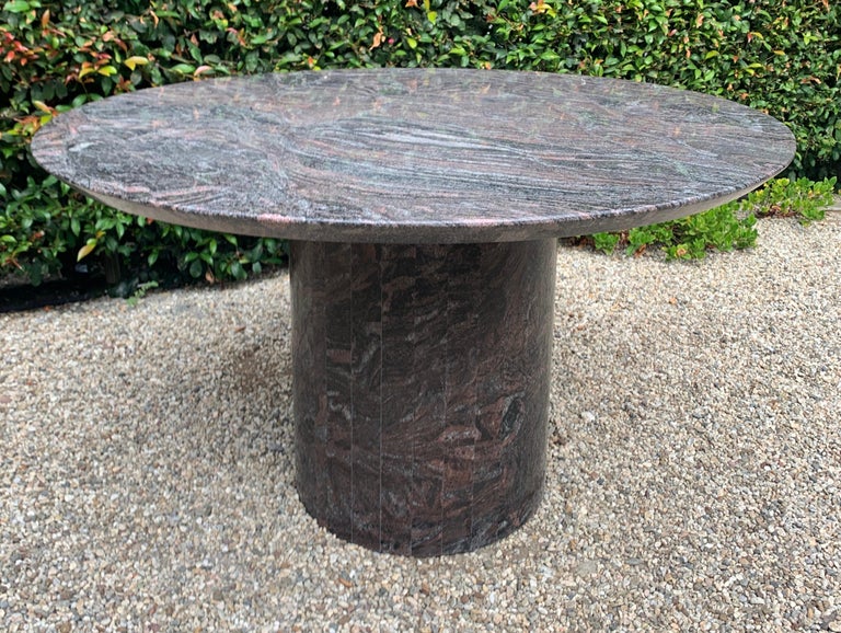 Custom granite dining table with 50 inch knife edge top and custom ribbed-cut cylinder base.  This table can easily seat up to six guests comfortably.  

The movement and pattern of the Granite top and base makes for a bold statement in any room,