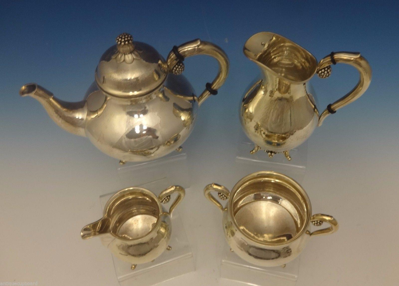Grann & Laglye
This lovely sterling silver 4-piece tea set was made by Grann & Laglye of Denmark. The pieces have a 3-D flower motif with beads on the finials, handles, and detail by the feet. Retailed by Dana Comp mark. The set dates from the