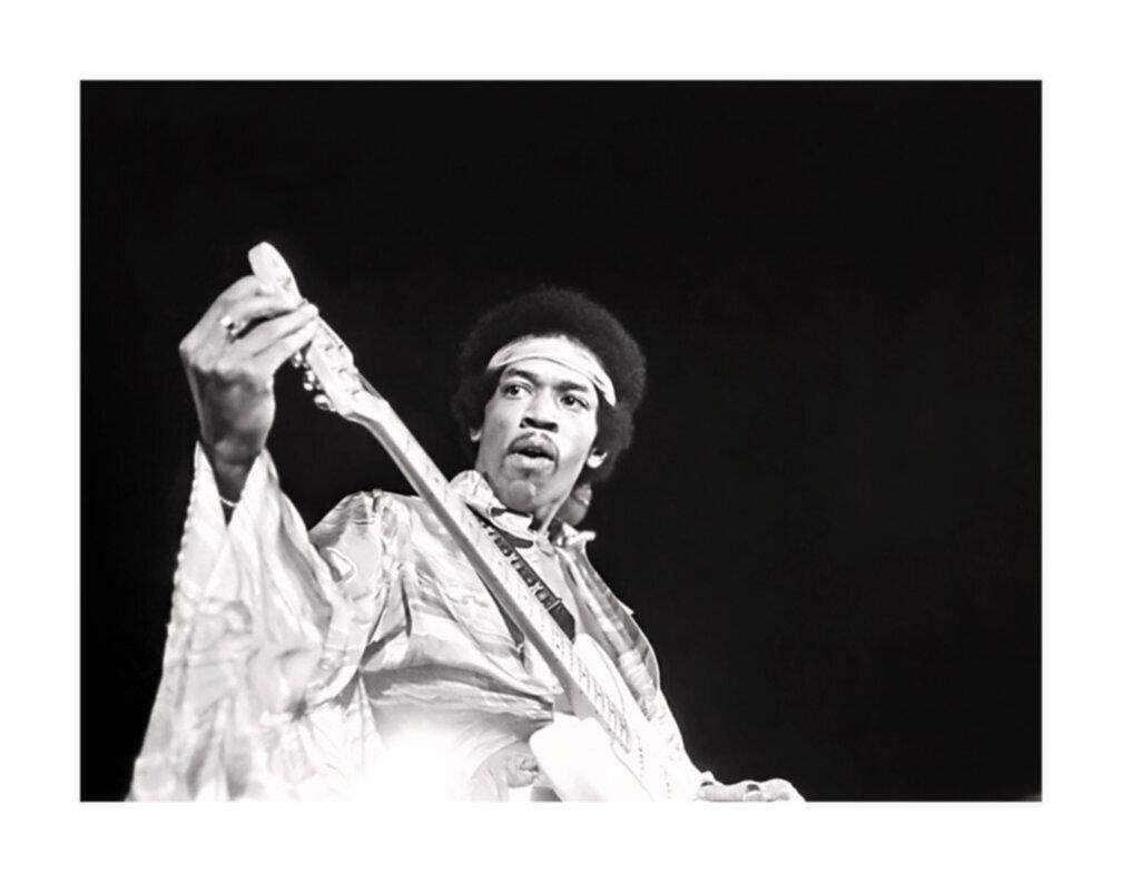 Black and White Photograph de Grant Harper Reid - Jimi Hendrix afinando la guitarra en el escenario