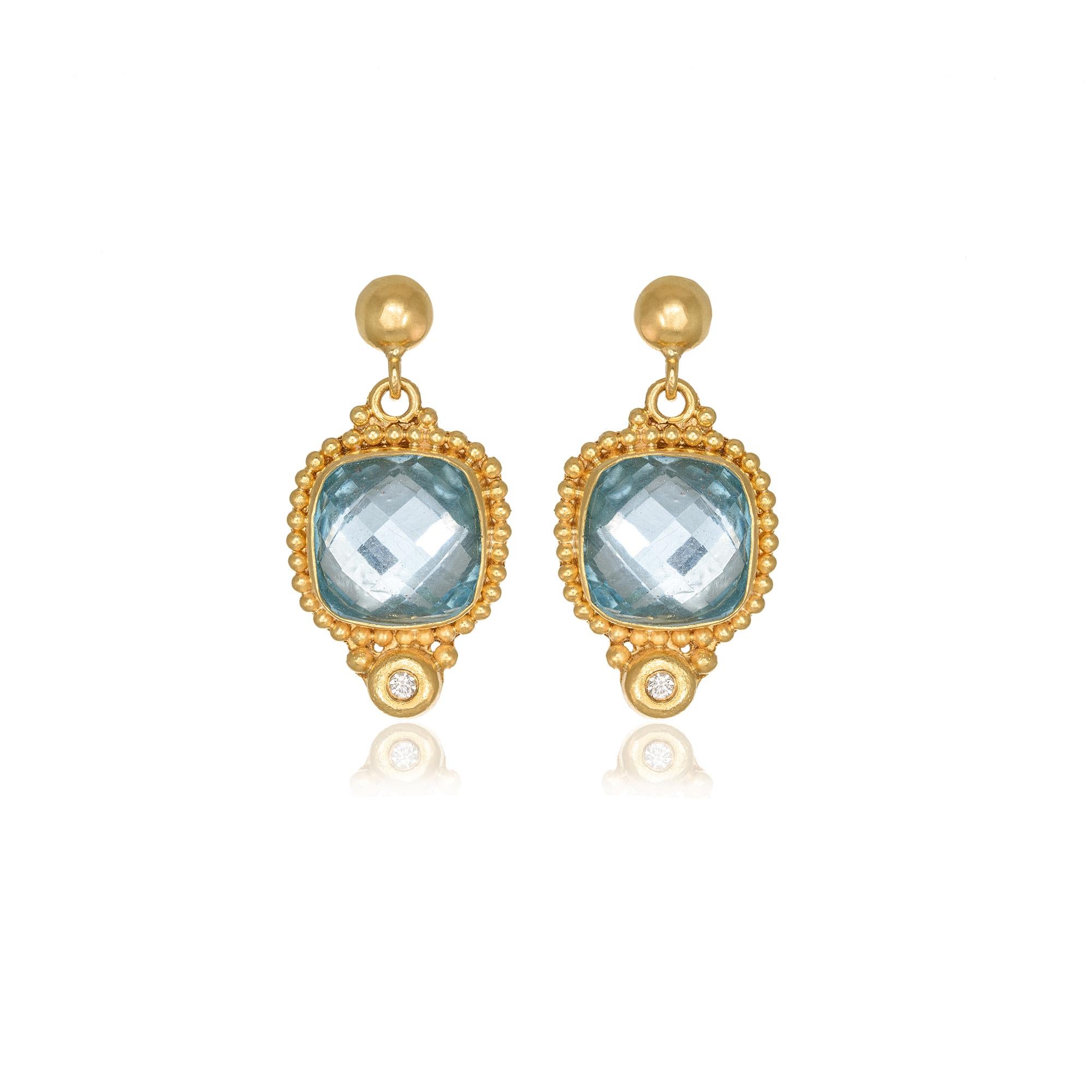 Drop earrings with cushion Blue Topazes and two briliiant cut diamonds, handcrafted in 22Kt yellow gold. This majestic pair of earrings is created using the superb technique of granulation, where minute gold beads are carefully put around the Blue