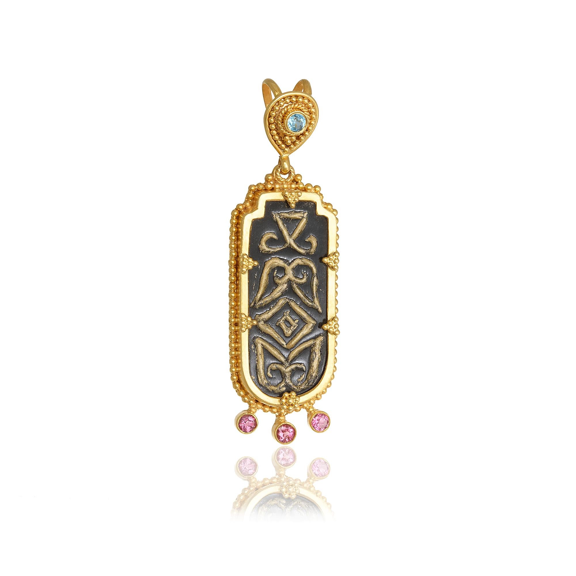 Oblong shape obsidian pendant necklace handcrafted in 22Kt yellow gold, featuring round Tourmalines and Blue Topazes. This elegant pendant necklace is braided using the traditional techniques of granulation and fligree. The minute gold beads around