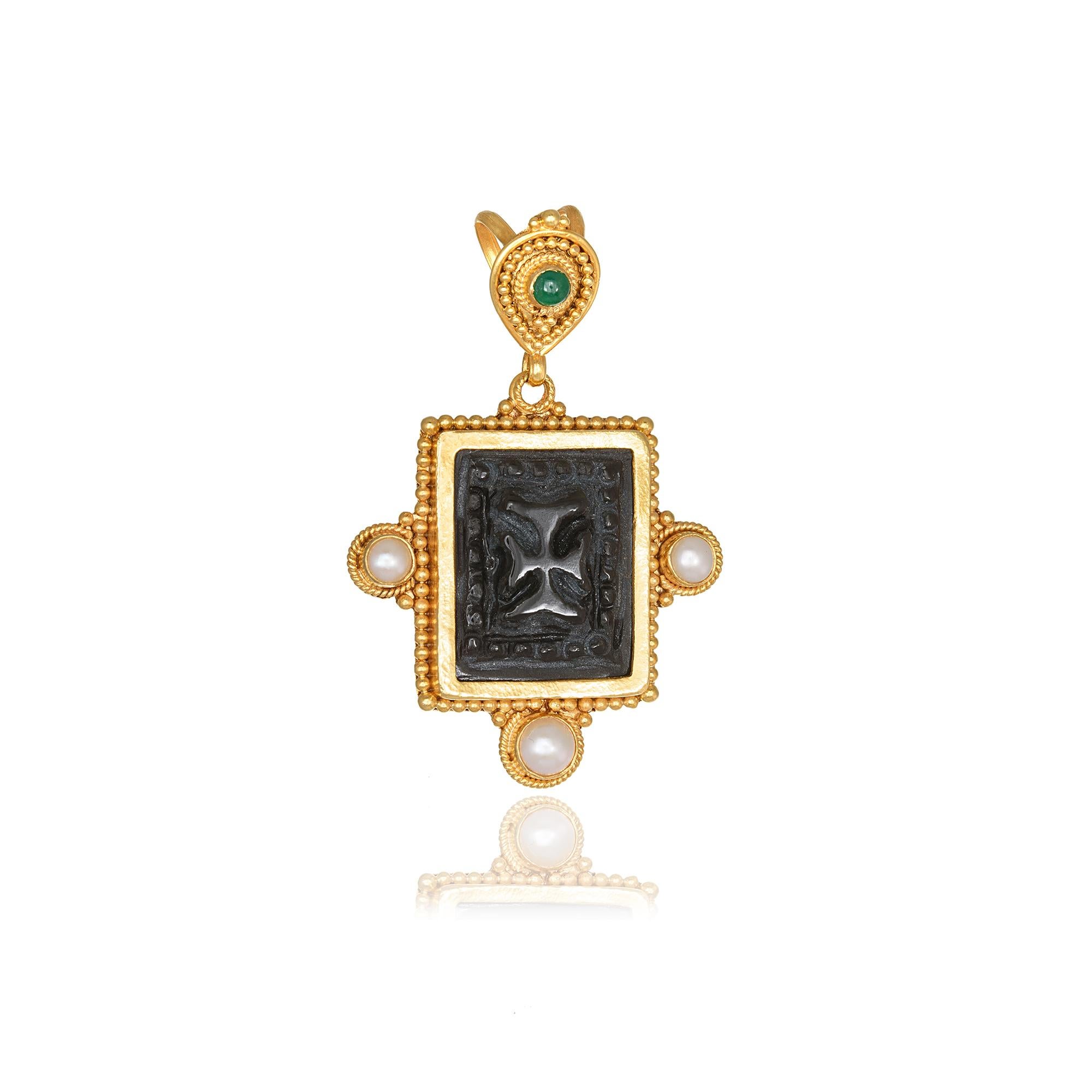 Obsidian Pendant with a hand carved byzantine cross on it, handcrafted with Granulation in 22Kt Yellow Gold, featuring three pearls and a round Emerald. This breathtaking pendant is braided using the traditional techniques of granulation and