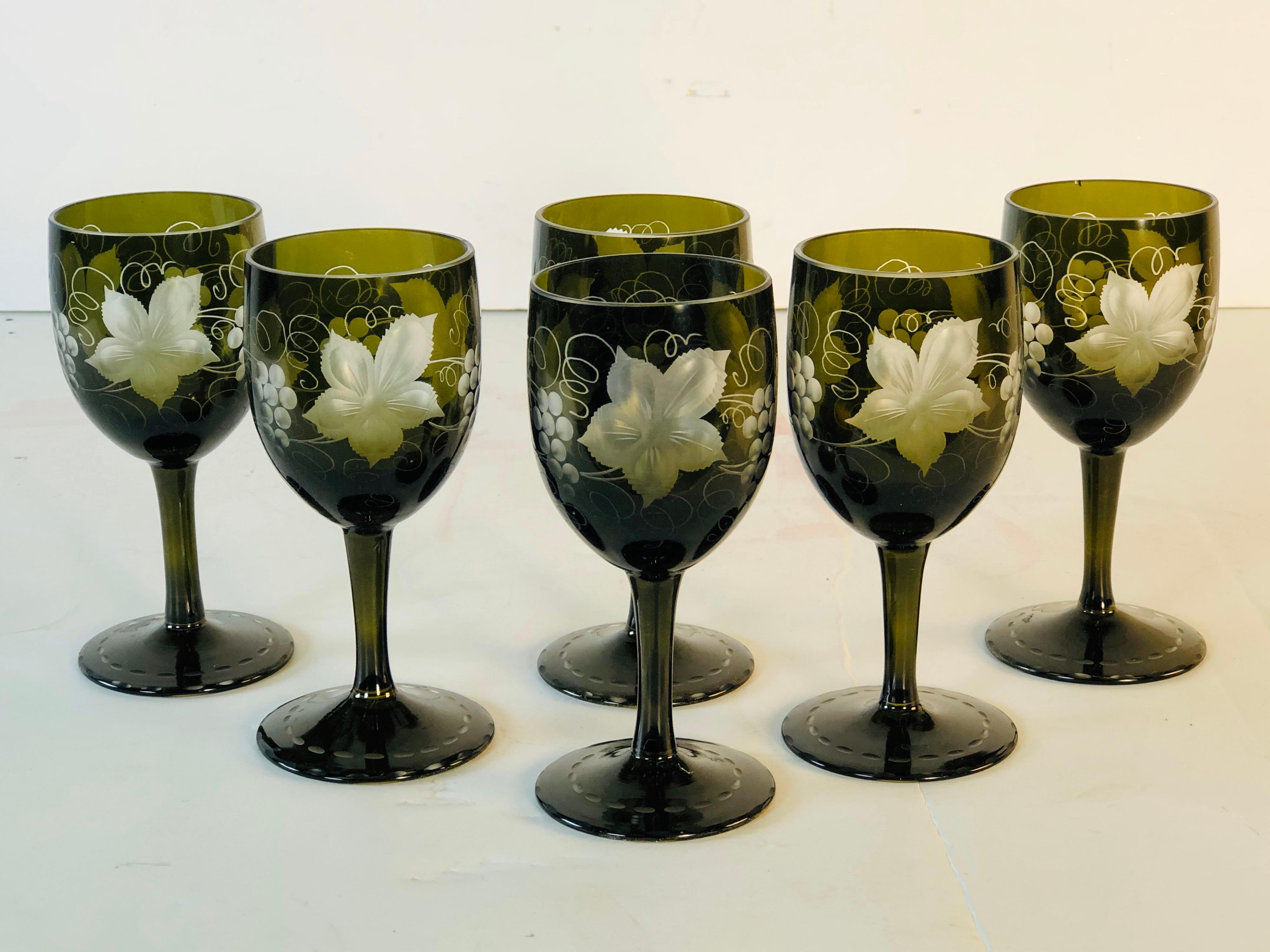 Vintage set of 6 wheel-cut green glass cordial stems with a grape leaf and vine pattern. The bases of the stems are also wheel-cut. No marks. Good condition with a couple of small rim nicks.