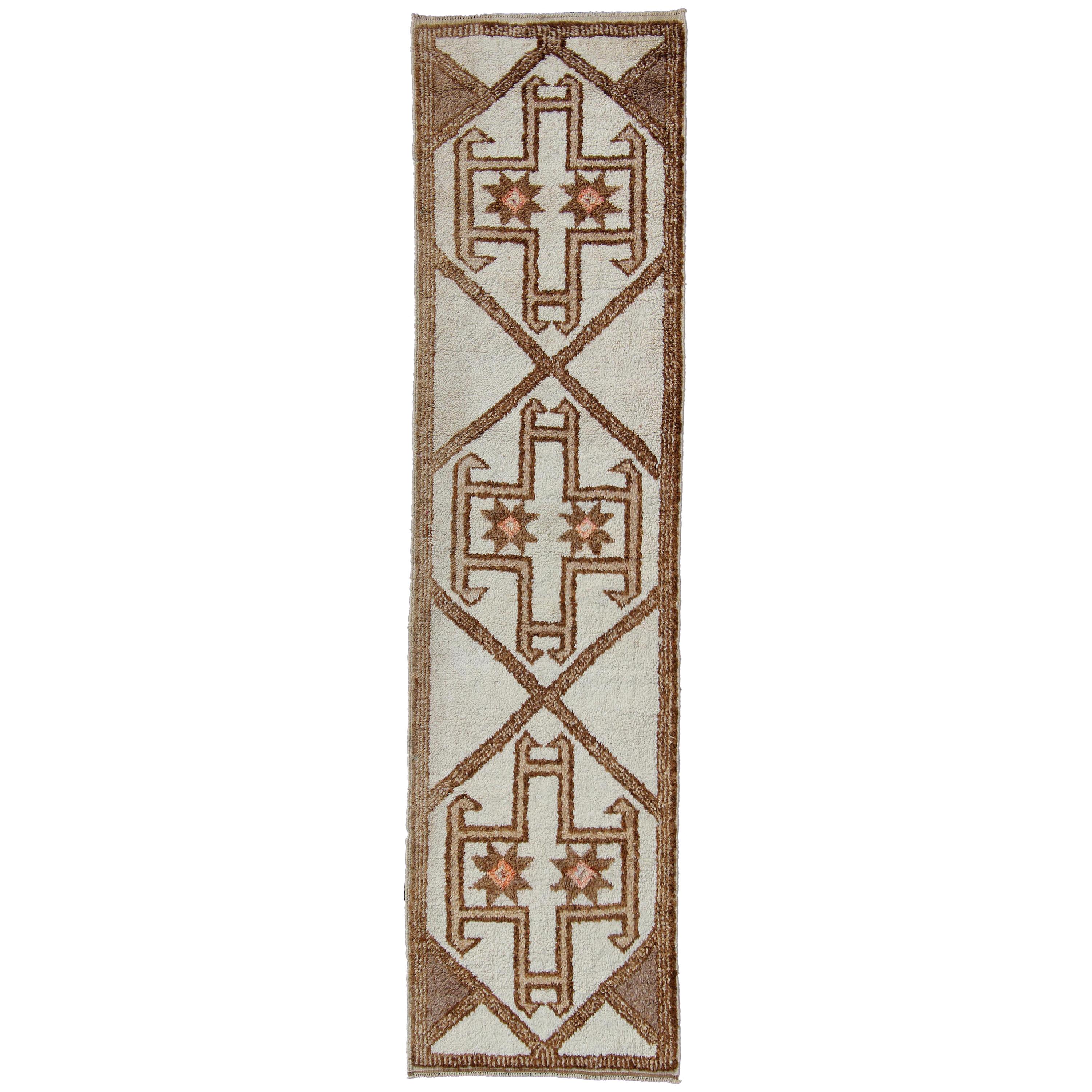 Runner vintage turco Tulu dal design grafico e geometrico nei colori crema, marrone e marrone.