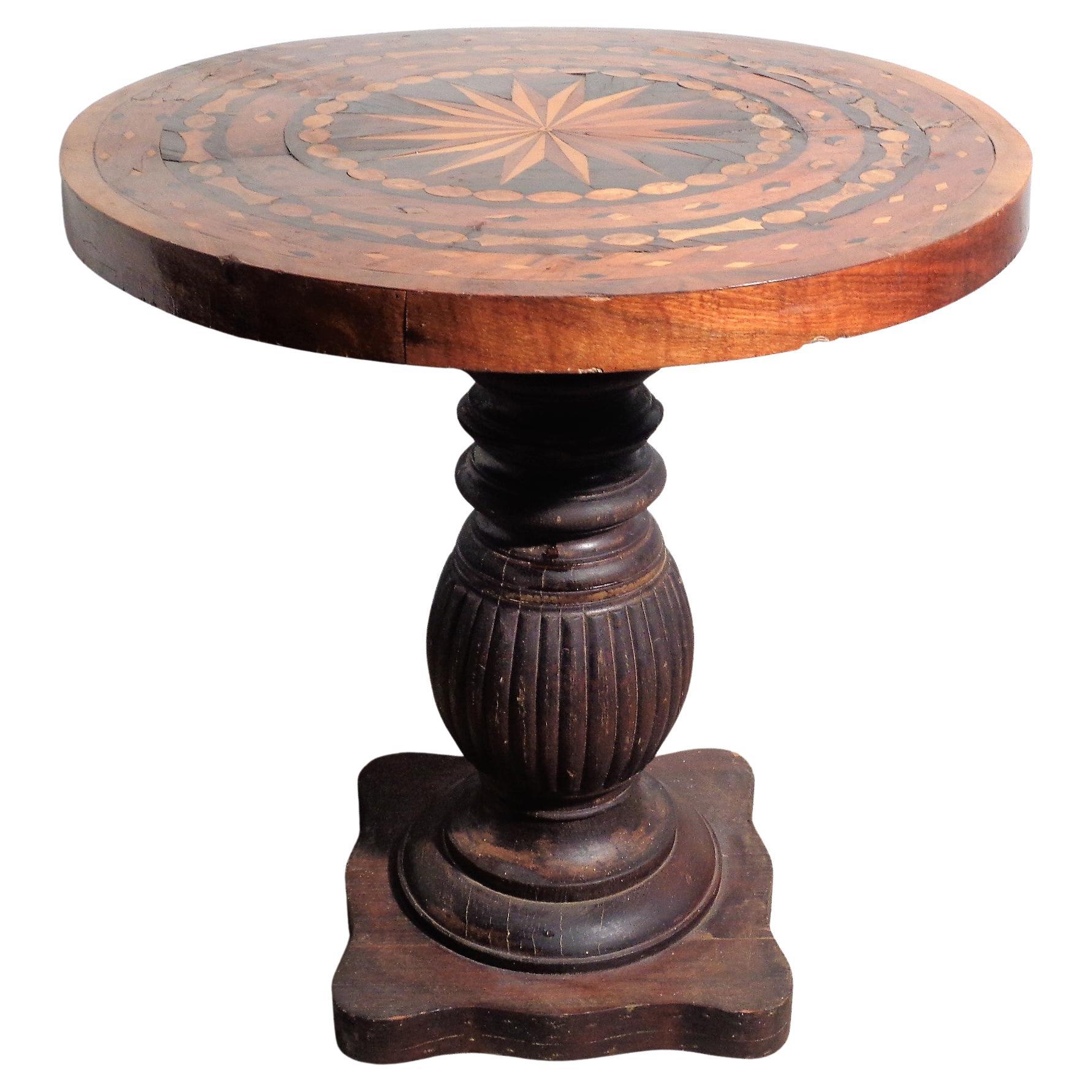 Antique parquetry inlaid circular top table with a bold compass design and beautifully aged contrasting wood veneers on an associated fluted baluster pedestal base.
Measures 23 1/2