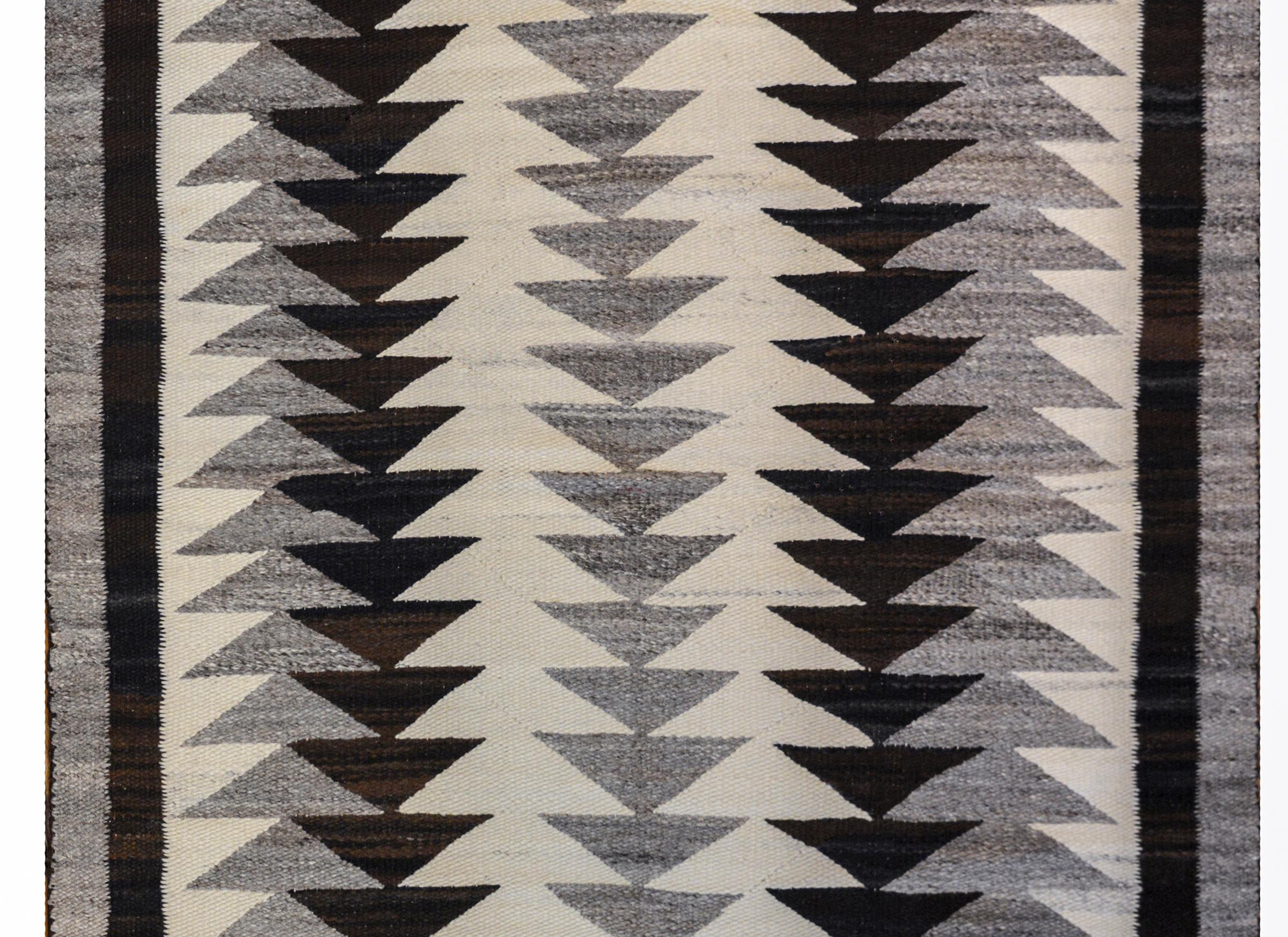 A wonderful early 20th century Navajo rug with an incredible bold black, white, and gray pattern of triangle stripes running the length of the rug.
