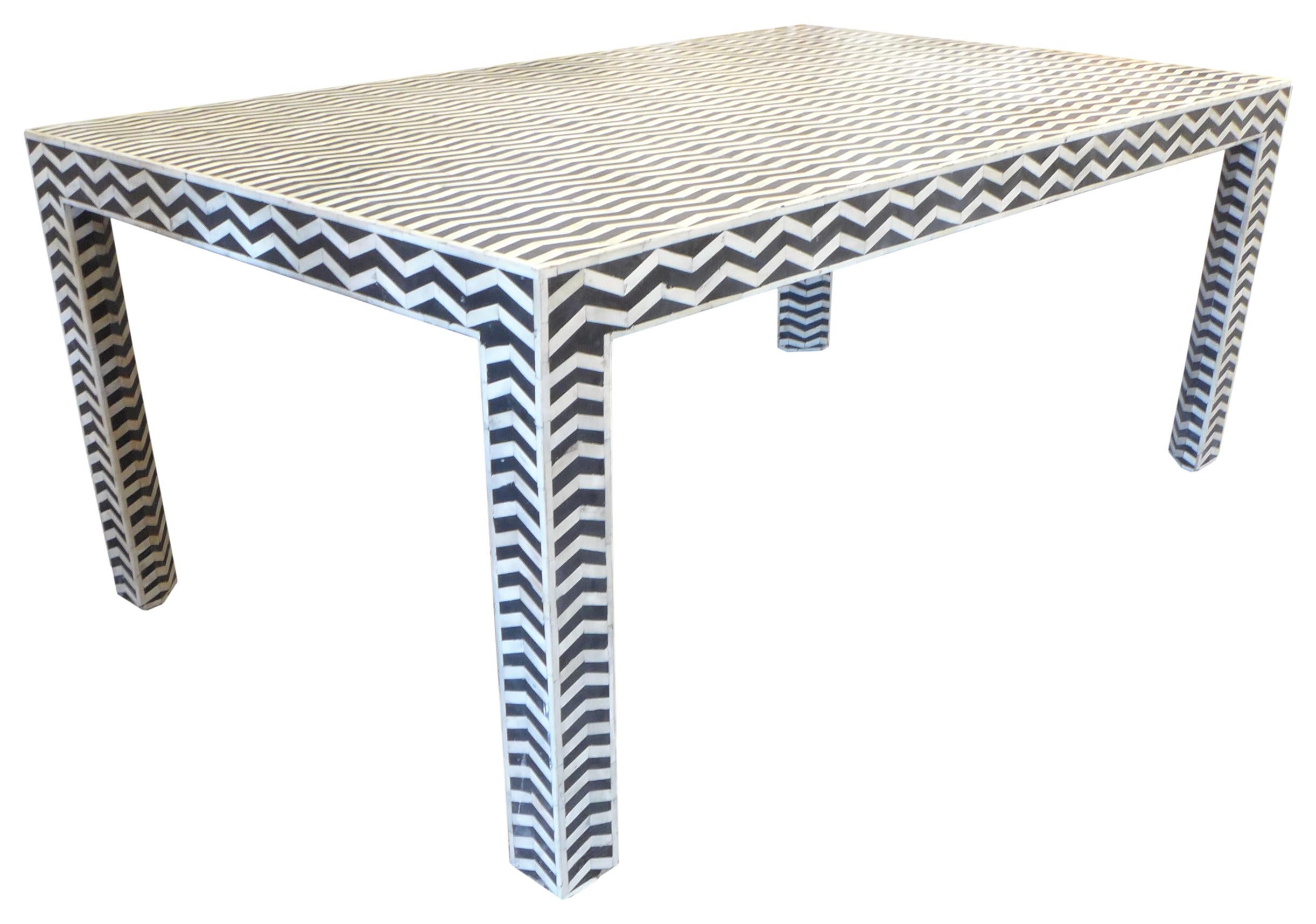 A fantastic faux ebony-and-ivory dining table. A simple, utilitarian wood dining table painstakingly mosaicked in zig-zag-stripe black and white resin. Clear African graphic inspiration and execution. Great patina throughout from age. A