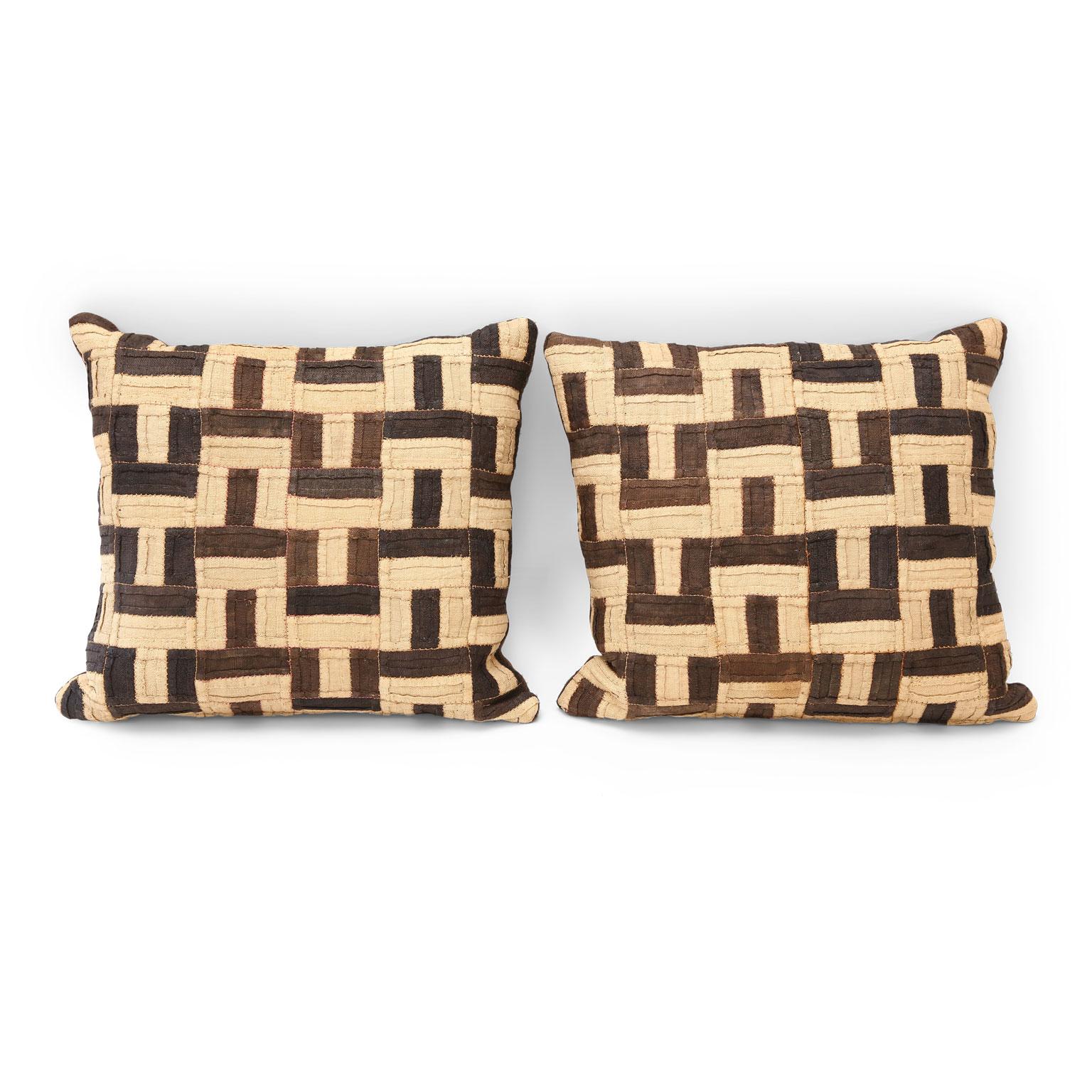 Graphic Kuba cloth cushions, two cushions made from a vintage Kuba cloth dance skirt. The raphia palm fabric is flat-weave and colored by vegetable dye in warm earth tones. Backed with dark brown hand-dyed vintage hemp. Cushions include zip
